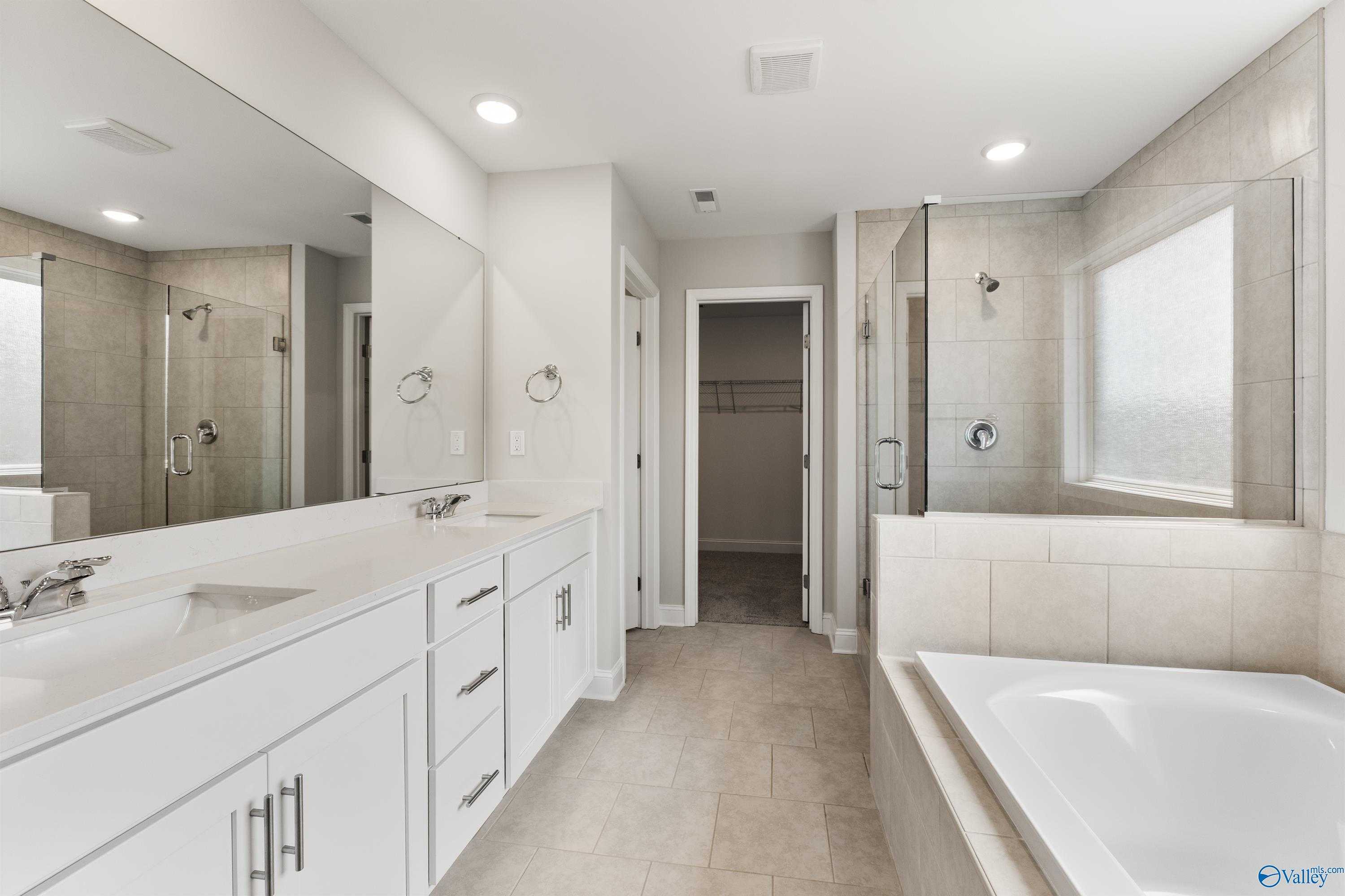 Elegant master bathroom featuring dual vanity, soaking tub, and glass shower in Davidson Homes The Madison A, Toney, AL