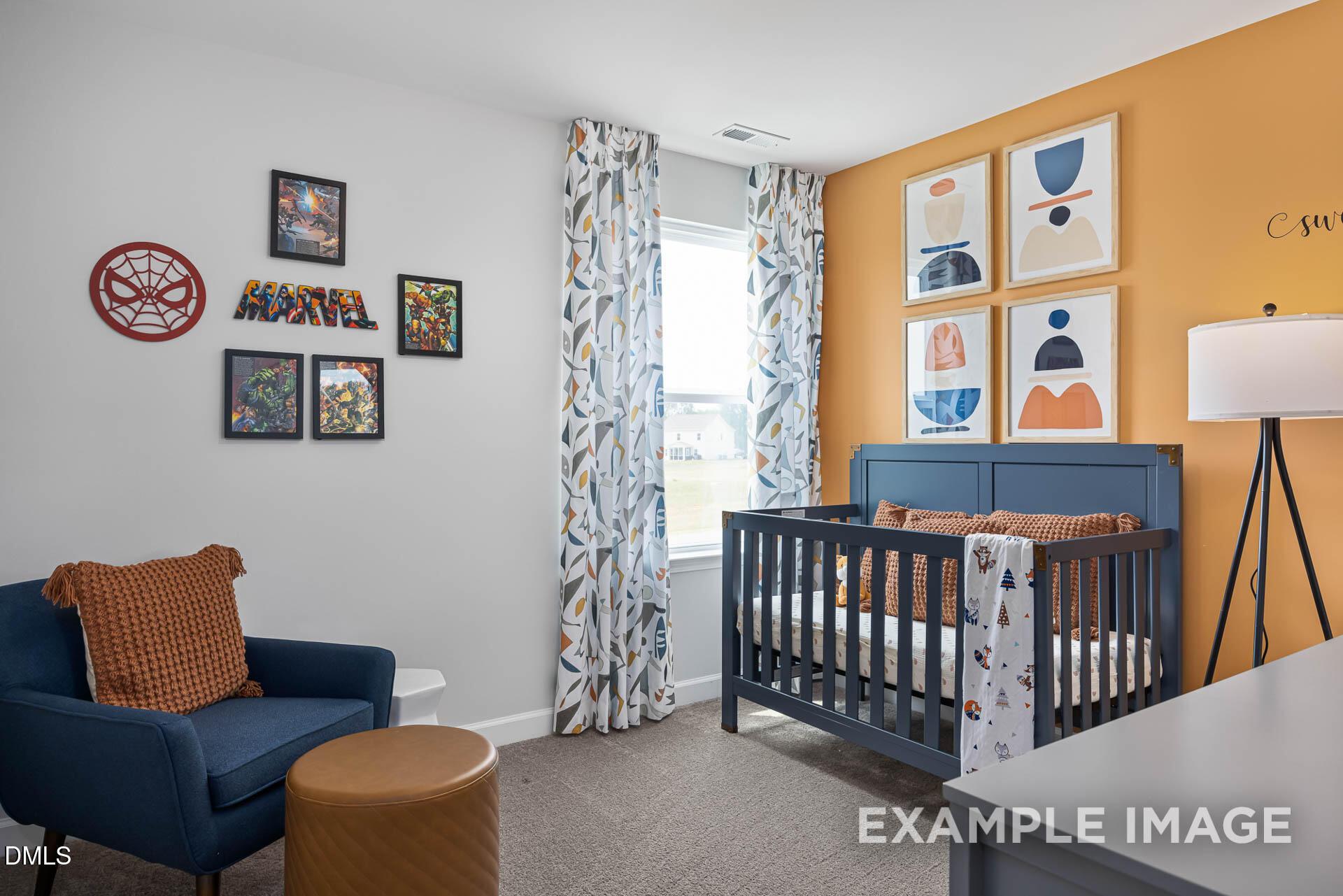 Modern nursery with navy crib, accent wall, and Marvel decor in The Adalynn A floor plan at Woodland Crossing, Zebulon, NC.