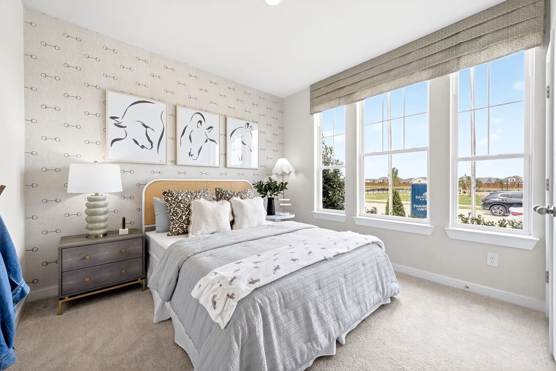 Cozy bedroom with patterned wallpaper and horse art in The Laurel I floor plan by Davidson Homes in Heartland, Texas.