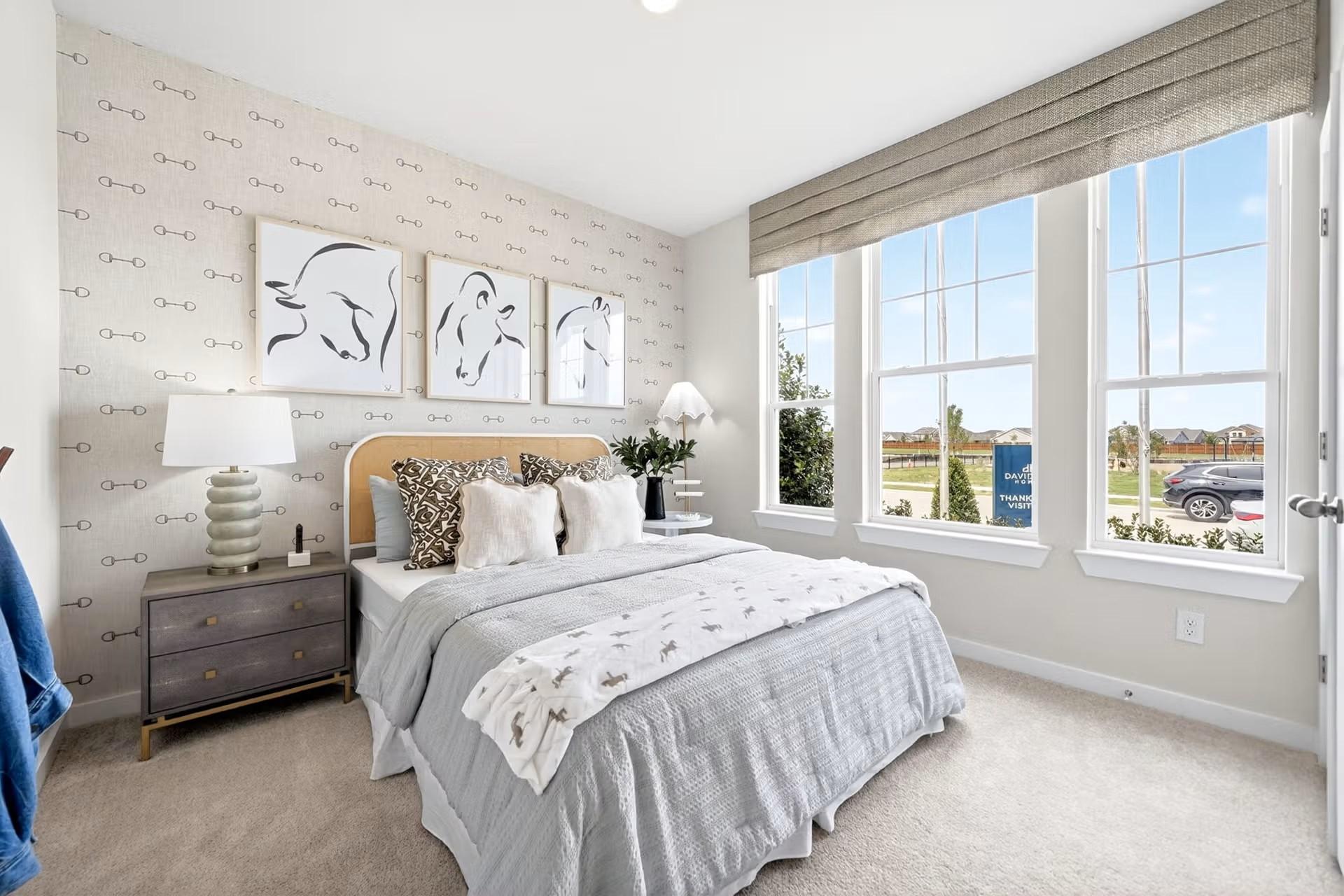Cozy bedroom with patterned wallpaper and horse art in The Laurel I floor plan by Davidson Homes in Heartland, Texas.