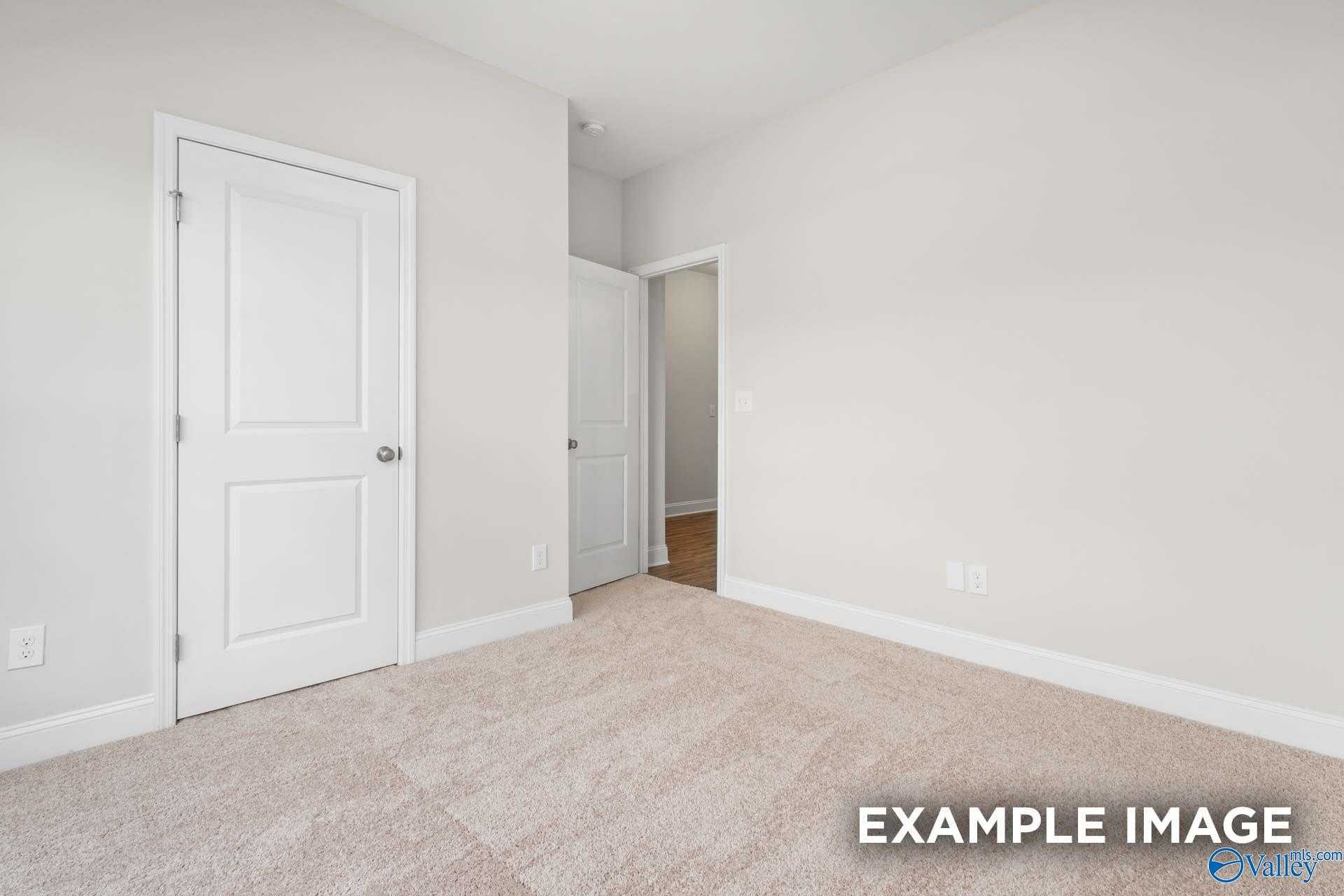 Bright secondary bedroom with white doors, neutral walls, and plush beige carpet in Davidson Homes The Franklin, Meridianville, Alabama