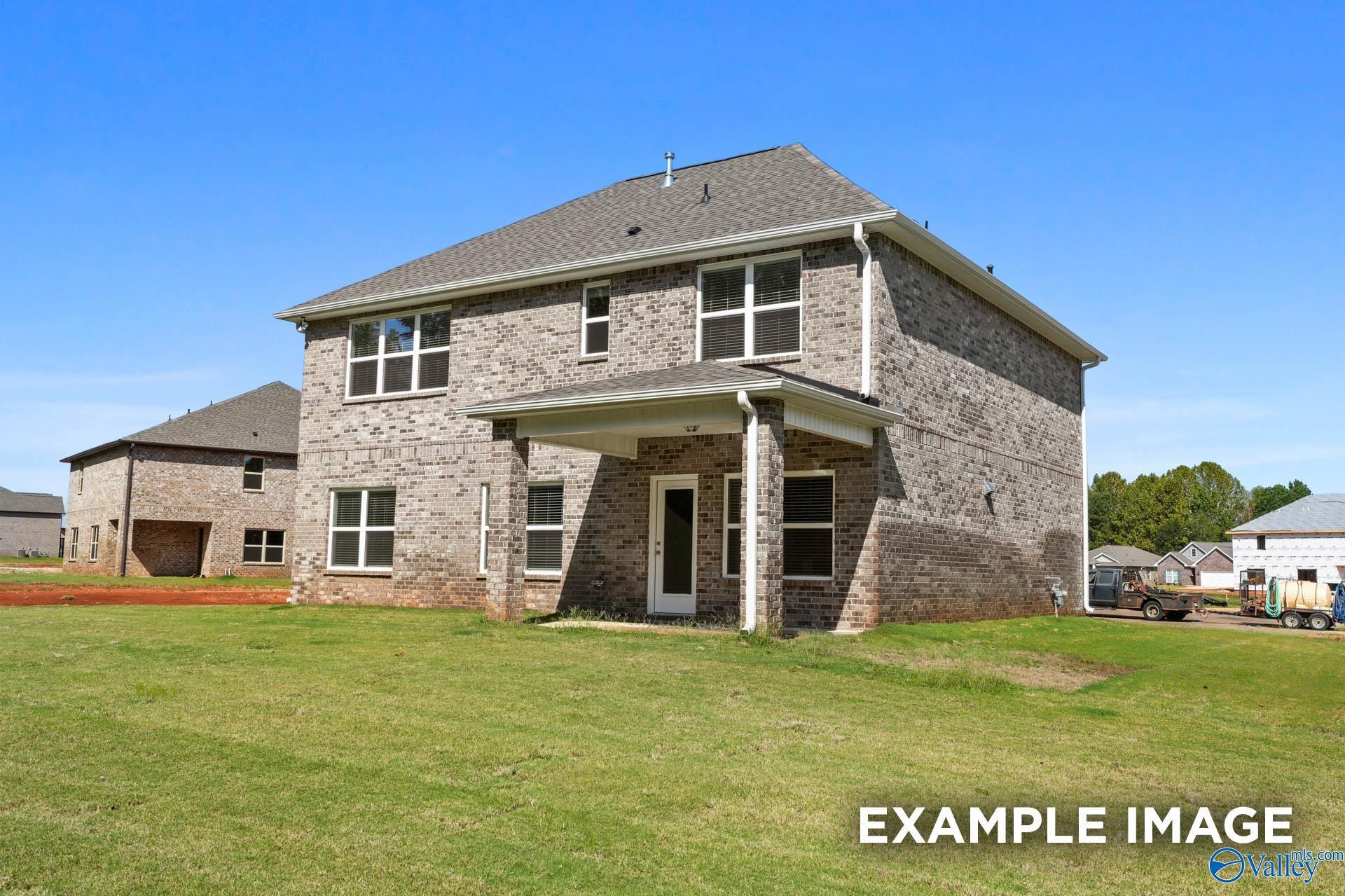 Two-story brick home with covered porch, two-car garage, and lush green yard in Clearview, Hazel Green, Alabama - Davidson Homes Shelby A
