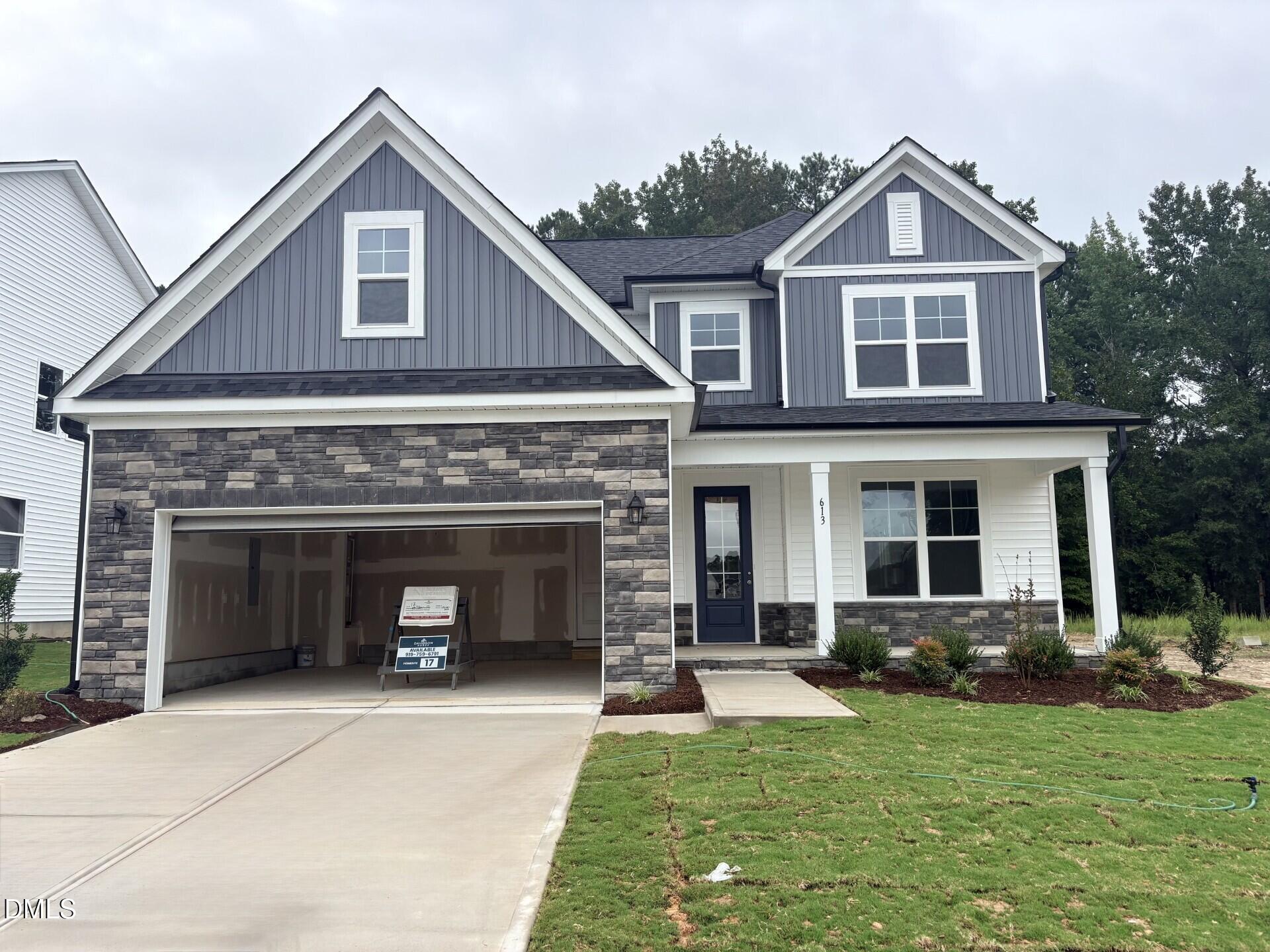 Two-story Davidson Homes Ash C exterior with stone accents, 2-car garage, and covered porch in Woodland Crossing, Zebulon, NC