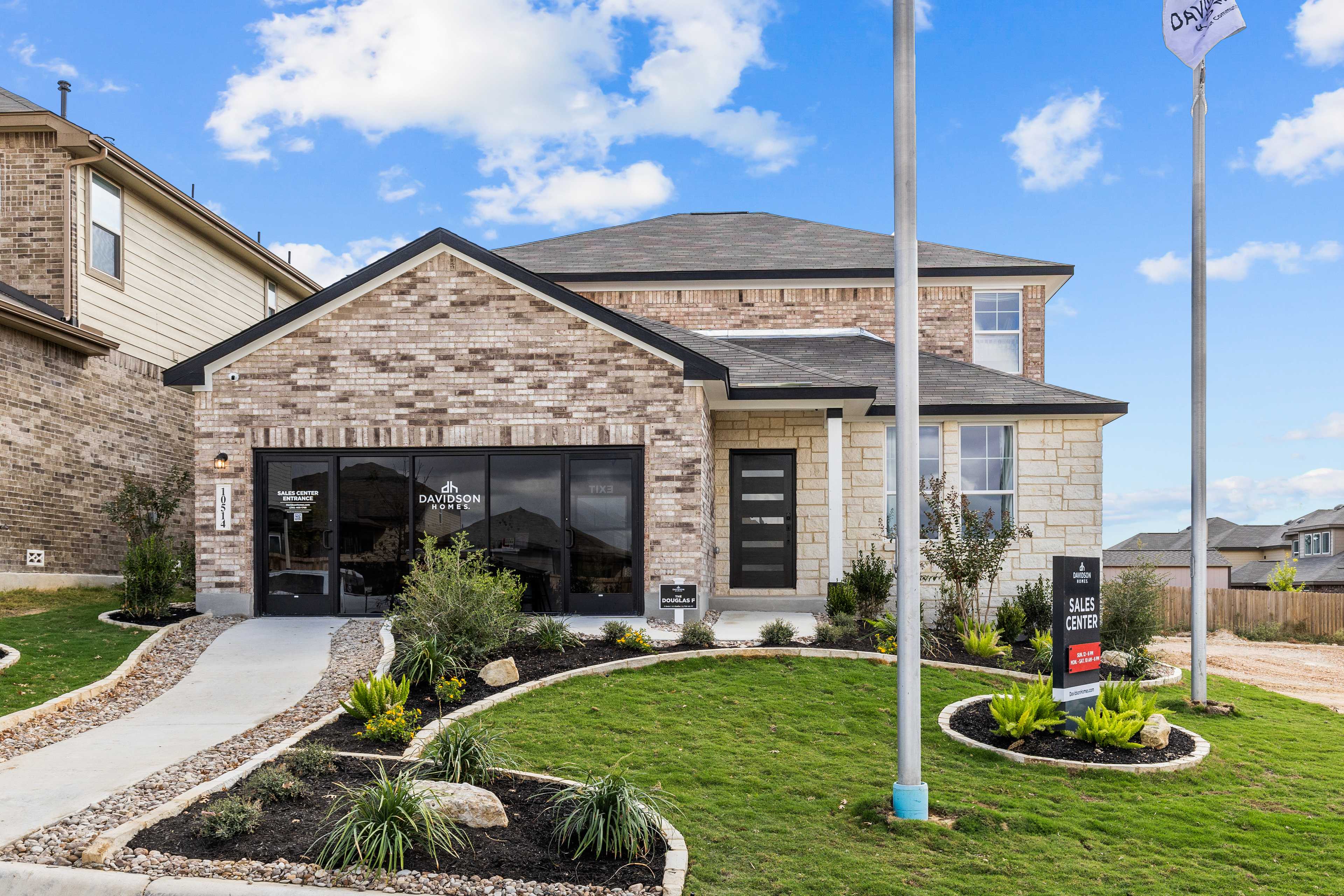 Brick single-story home exterior at Bricewood in San Antonio TX by Davidson Homes with garage, landscaping and for-sale sign