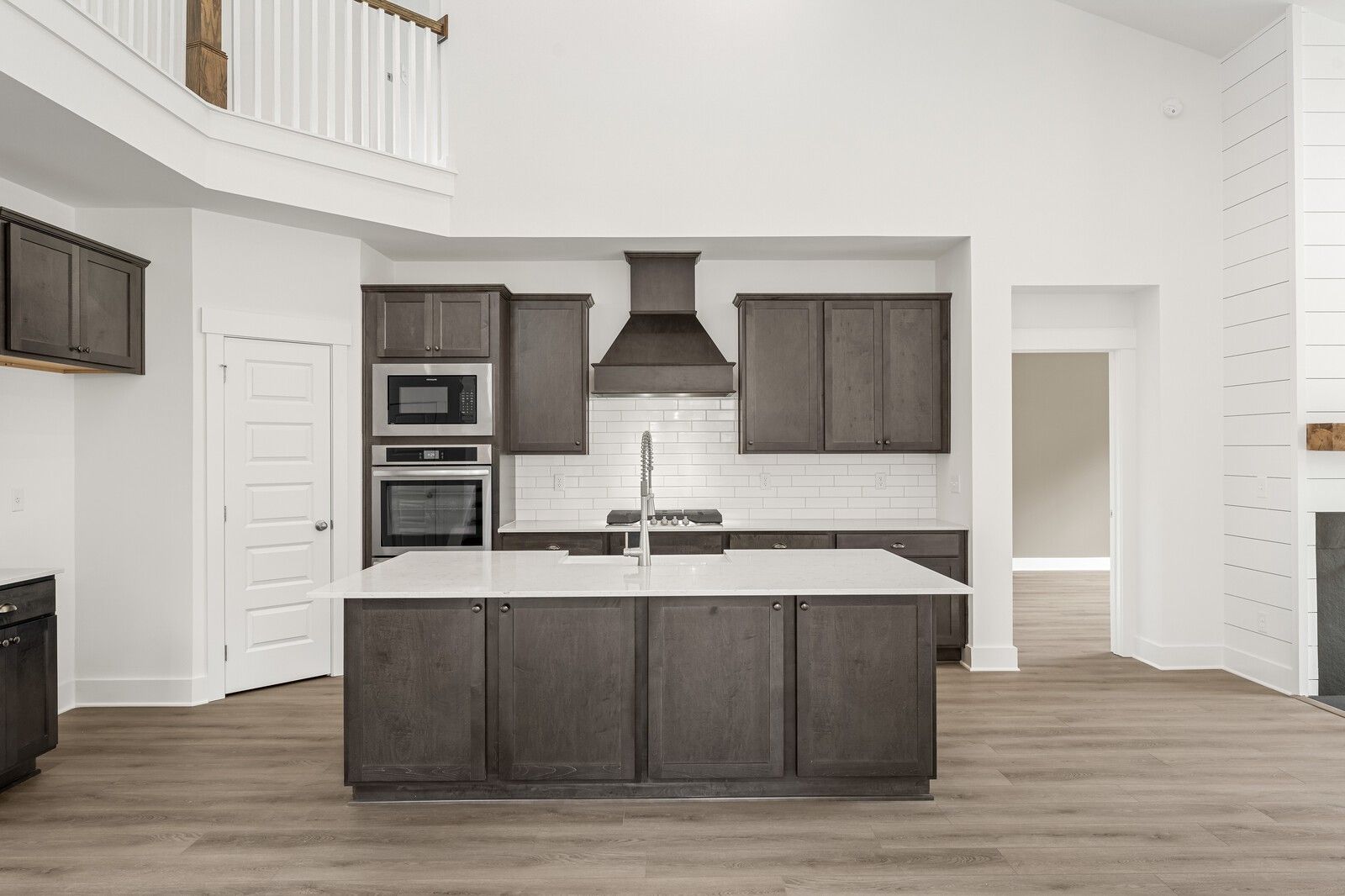 Modern kitchen with dark cabinets, quartz island, and white subway tile in The Ridgeport C home by Davidson Homes, Gallatin.