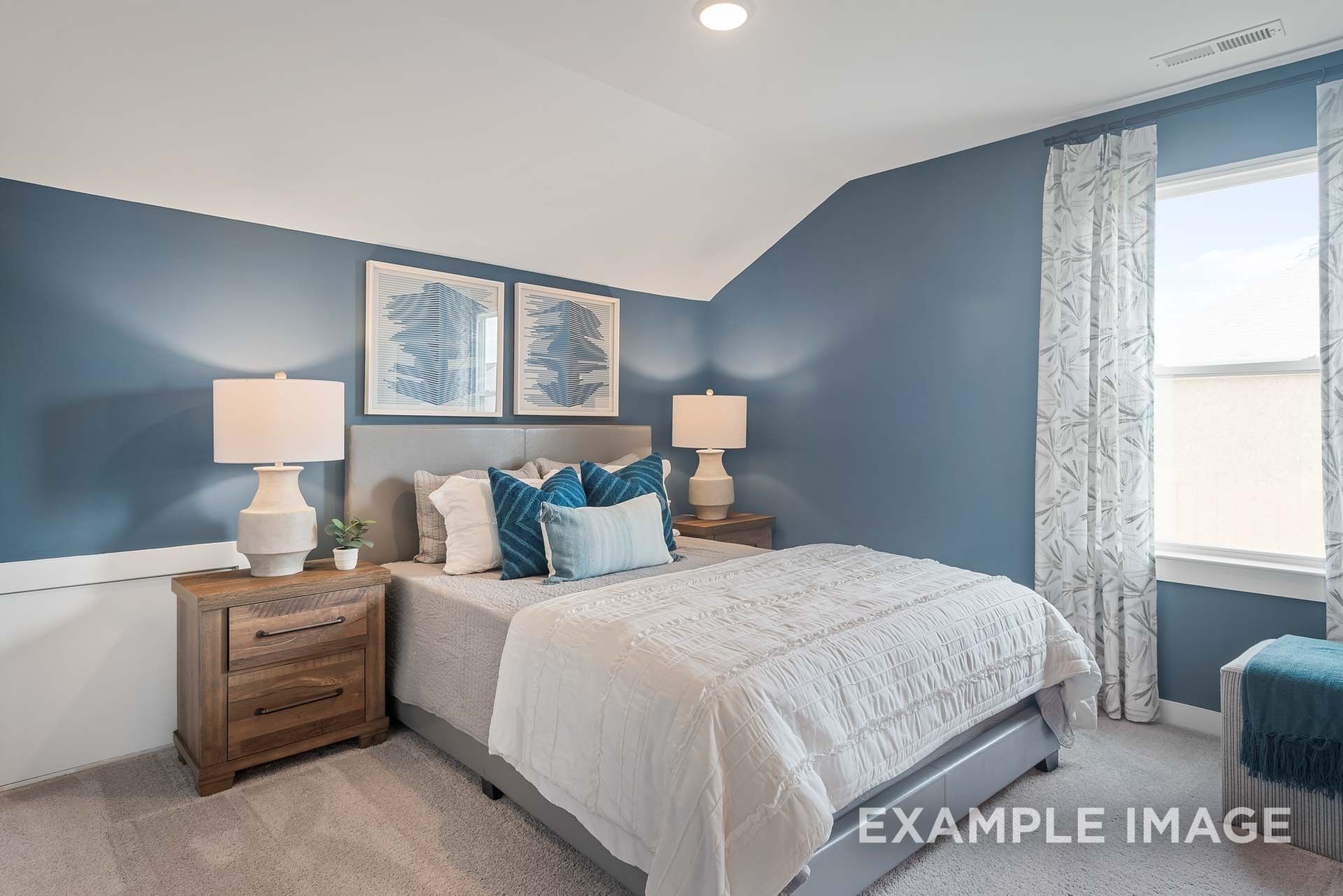 Serene blue master bedroom with king bed, tufted headboard, lamps, abstract art, and large window in Davidson Homes The Ridgeport C, Gallatin TN