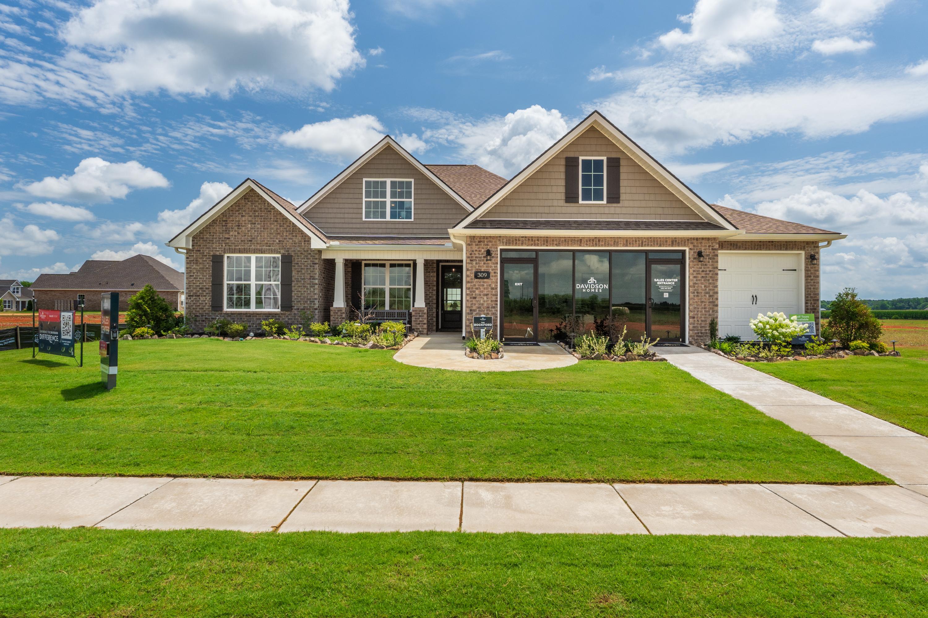 Craftsman brick home exterior at Kendall Farms in Toney Alabama with gabled roof large windows and manicured lawn