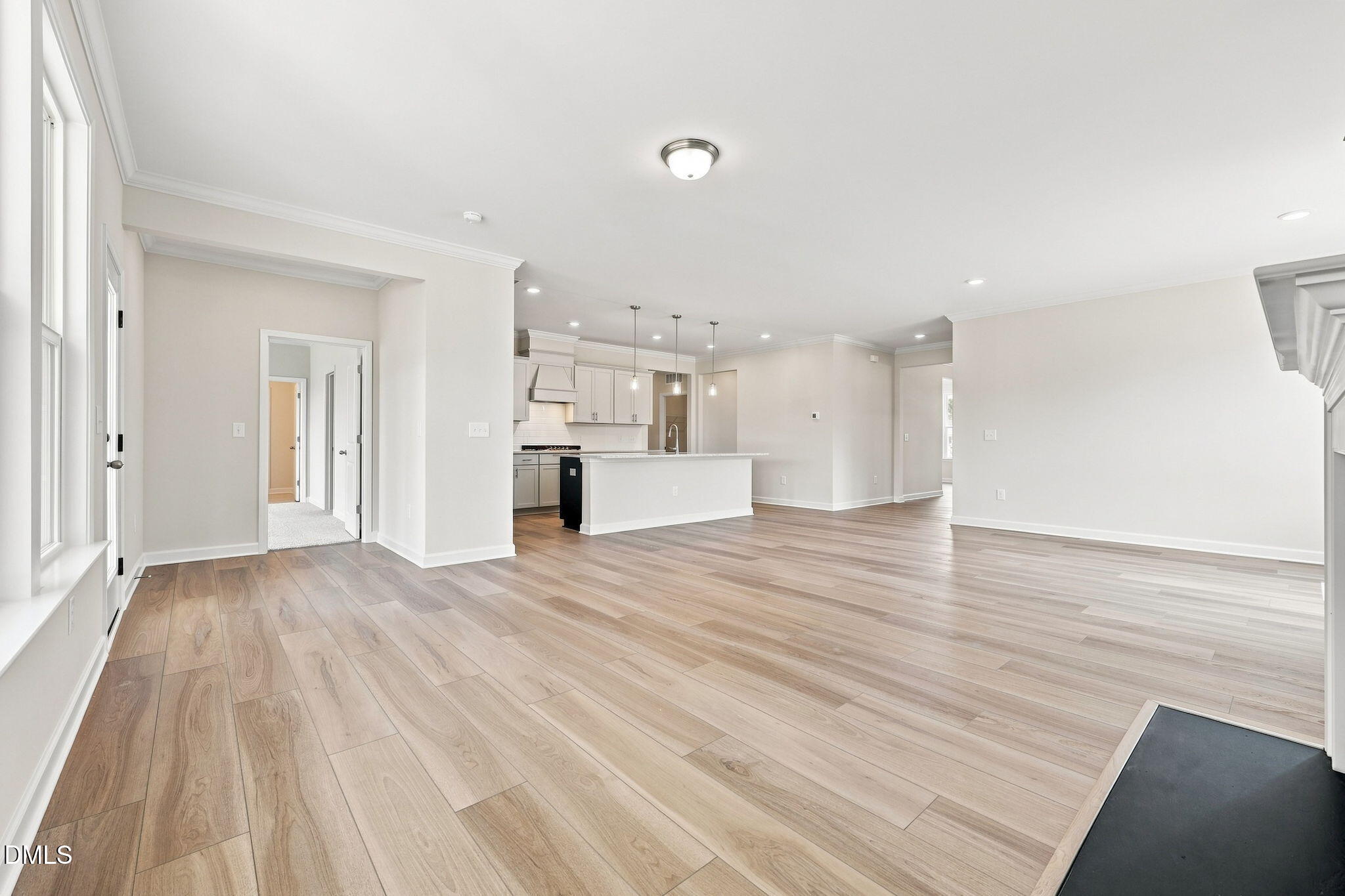 Open-concept living room and kitchen with light wood floors in The Magnolia B floor plan, Retreat at North Main, Lillington.