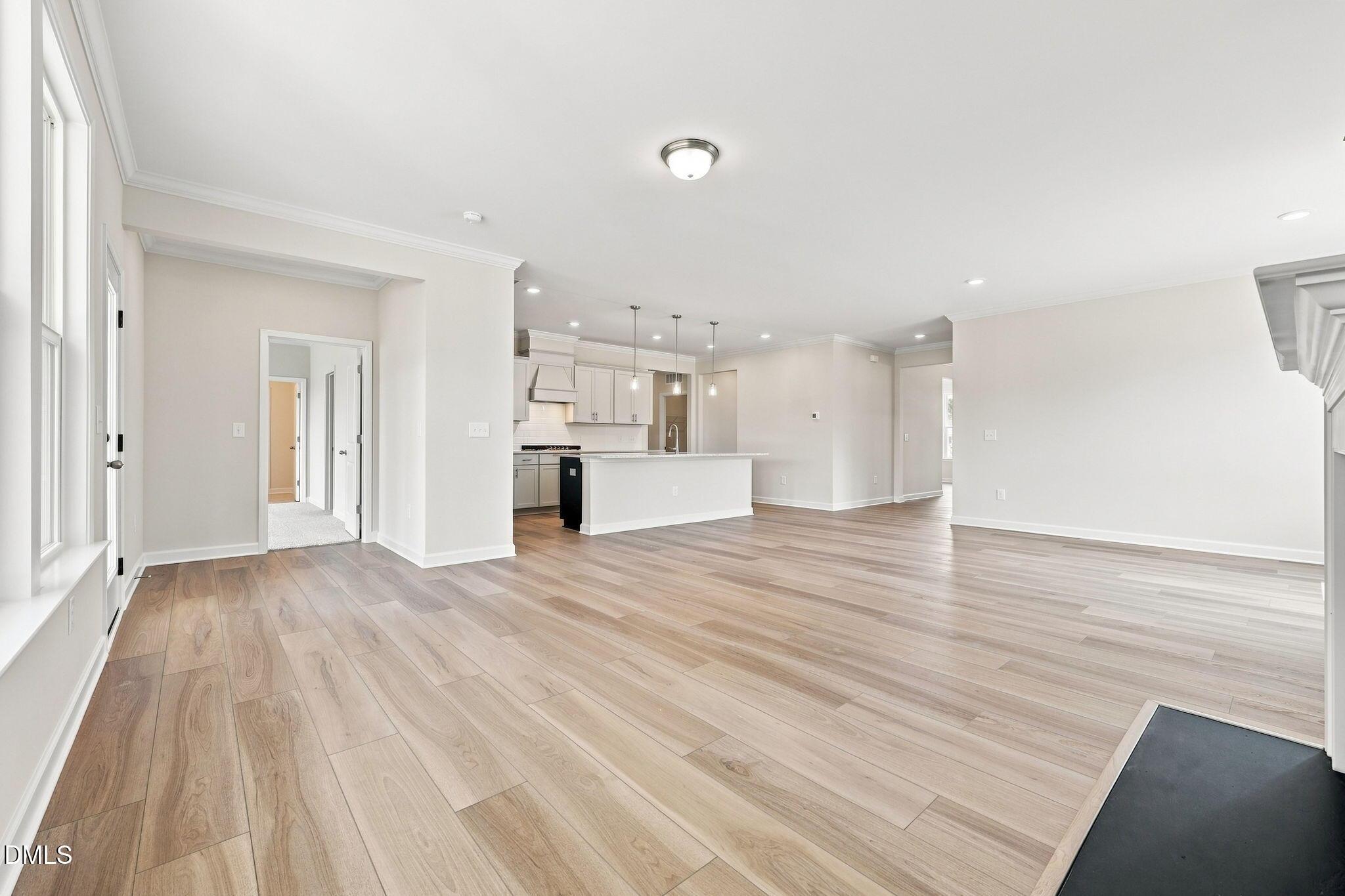 Open-concept living room and kitchen with light wood floors in The Magnolia B floor plan, Retreat at North Main, Lillington.