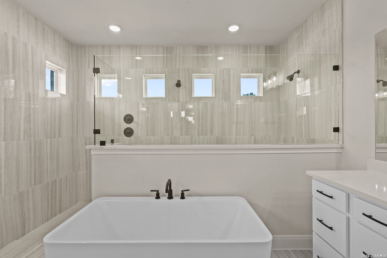 Modern bathroom with freestanding soaking tub and glass-enclosed walk-in shower in Davidson Homes Summerlin B, Castroville.