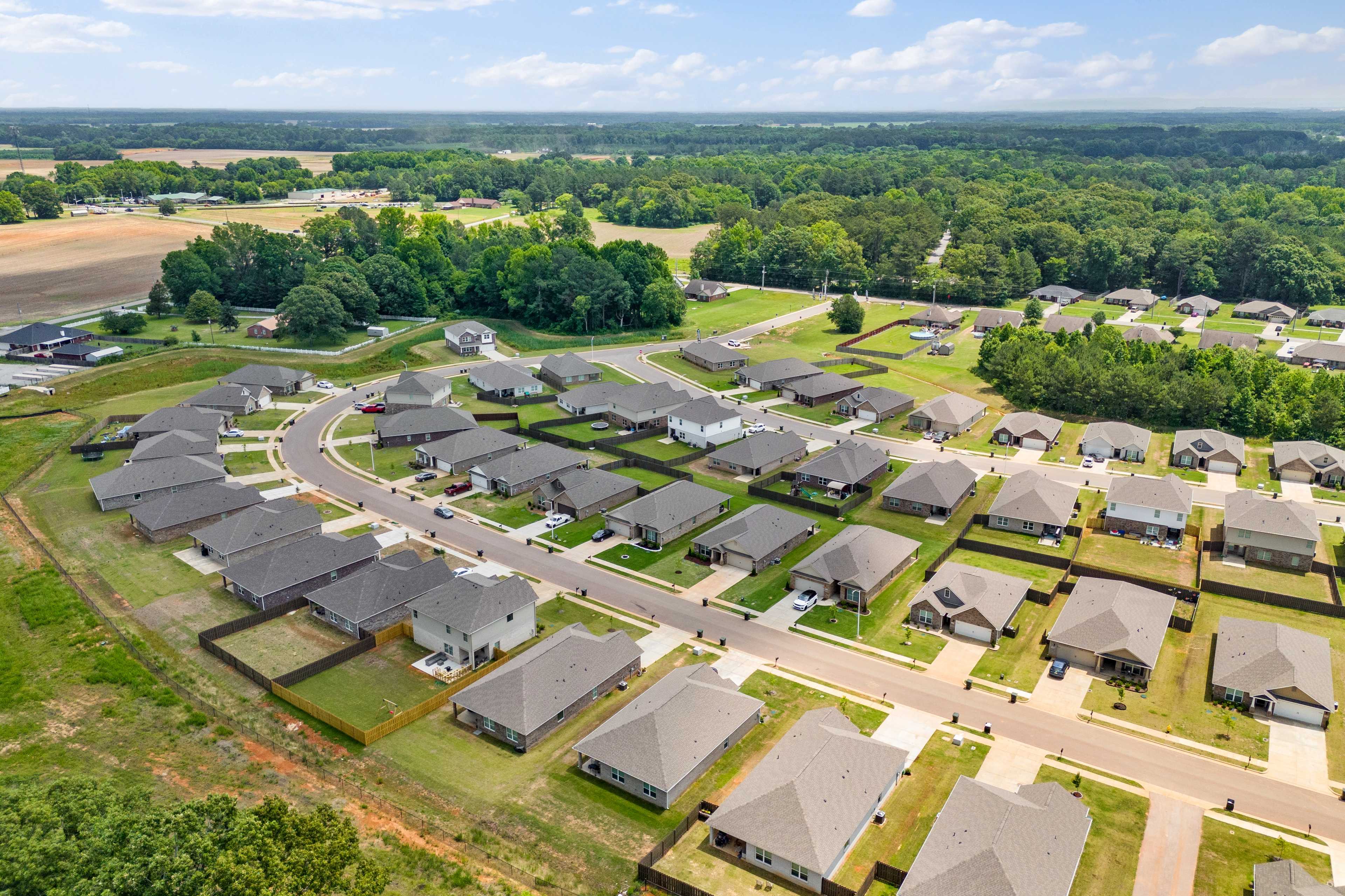 Aerial view of Durham Farms neighborhood in Harvest Alabama with clustered modern homes curved streets and lush green fields