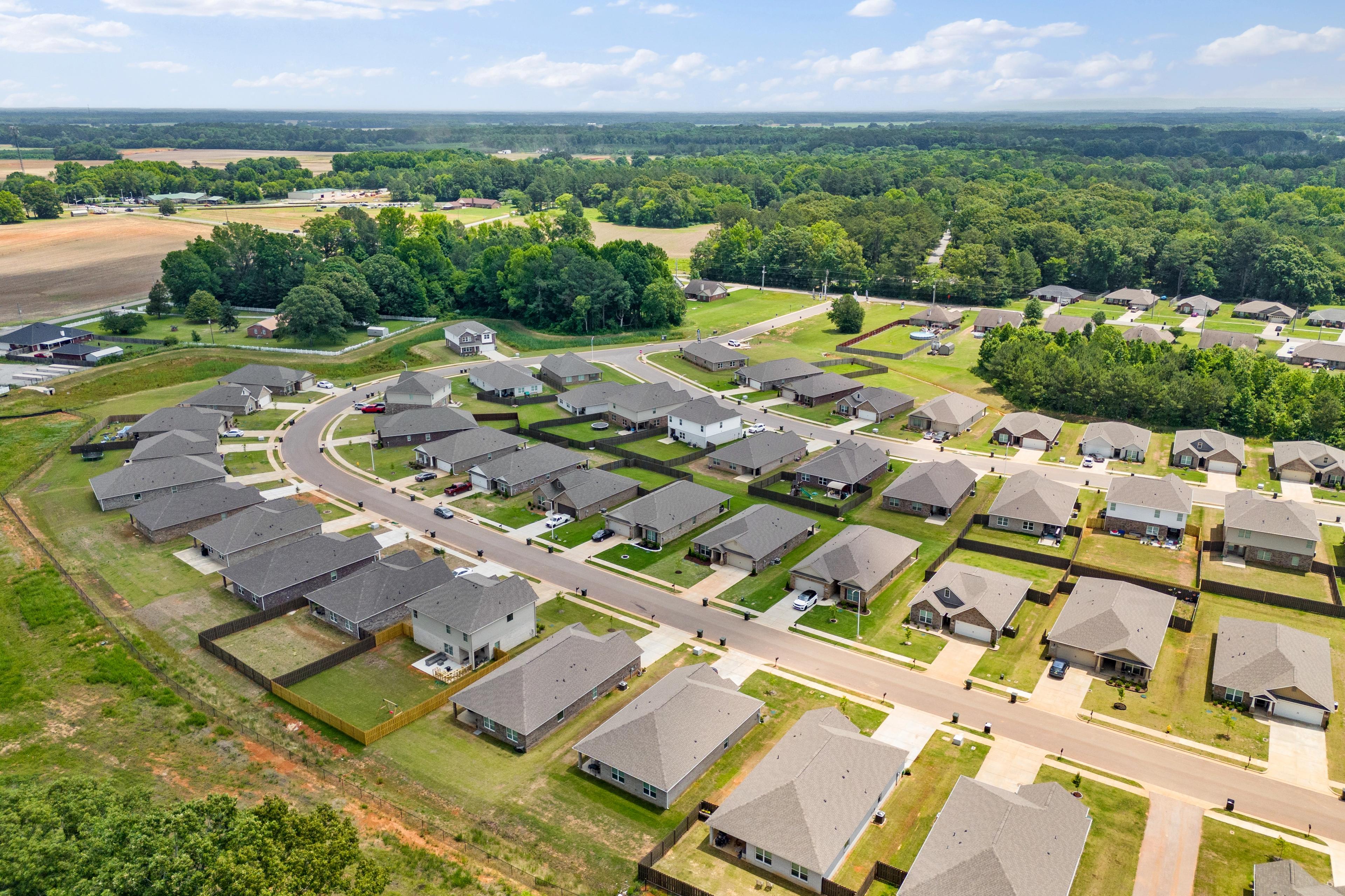 Aerial view of Durham Farms neighborhood in Harvest Alabama with clustered modern homes curved streets and lush green fields