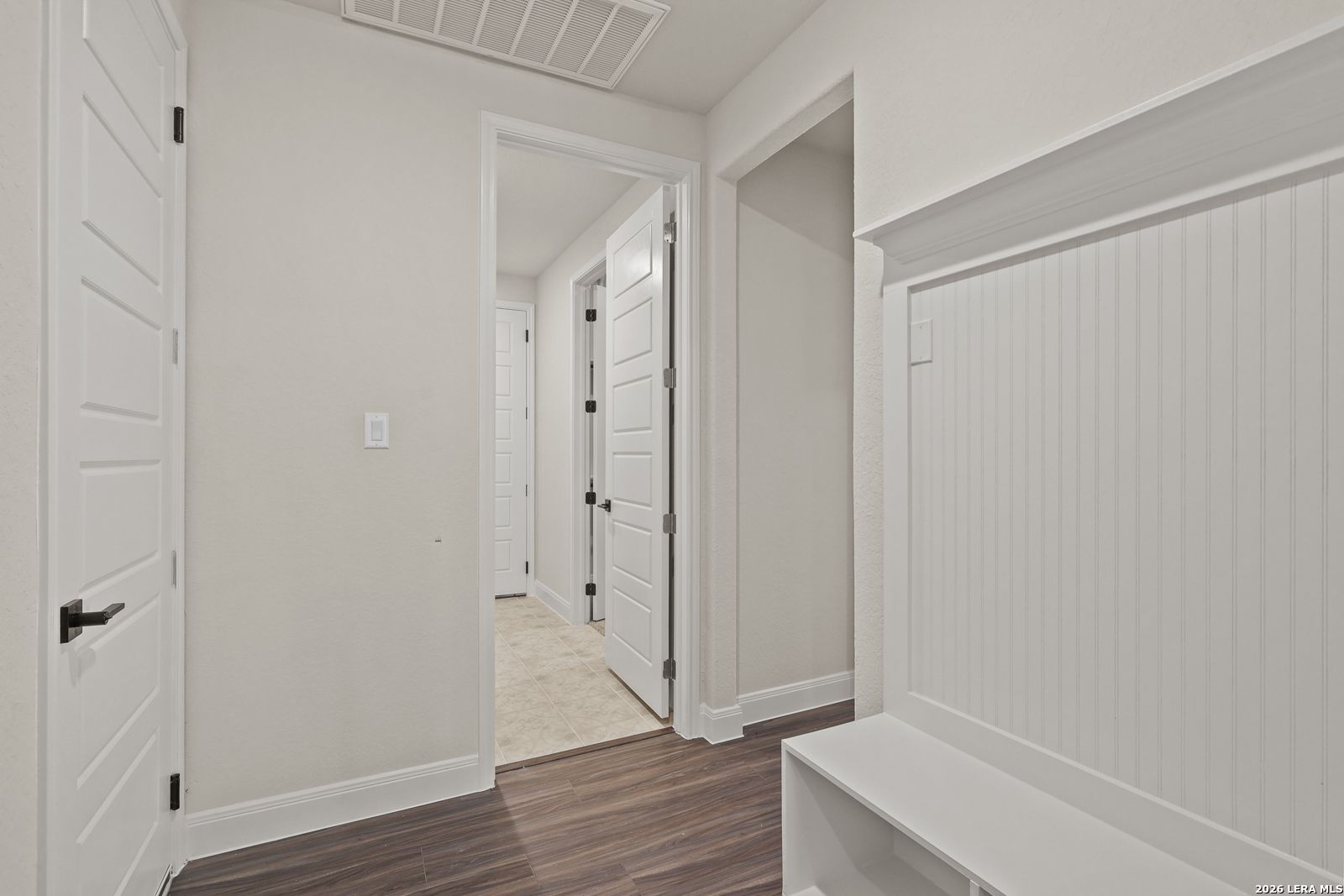 White mudroom bench with beadboard detail in the Summerlin B floor plan at Potranco Oaks, Castroville, Texas.