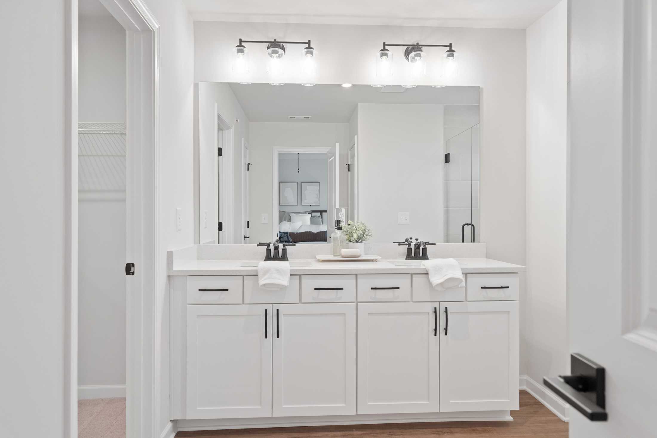 Spacious primary bathroom at Rosehill Townhomes in Marietta GA featuring double white vanity, large mirror, and modern lighting