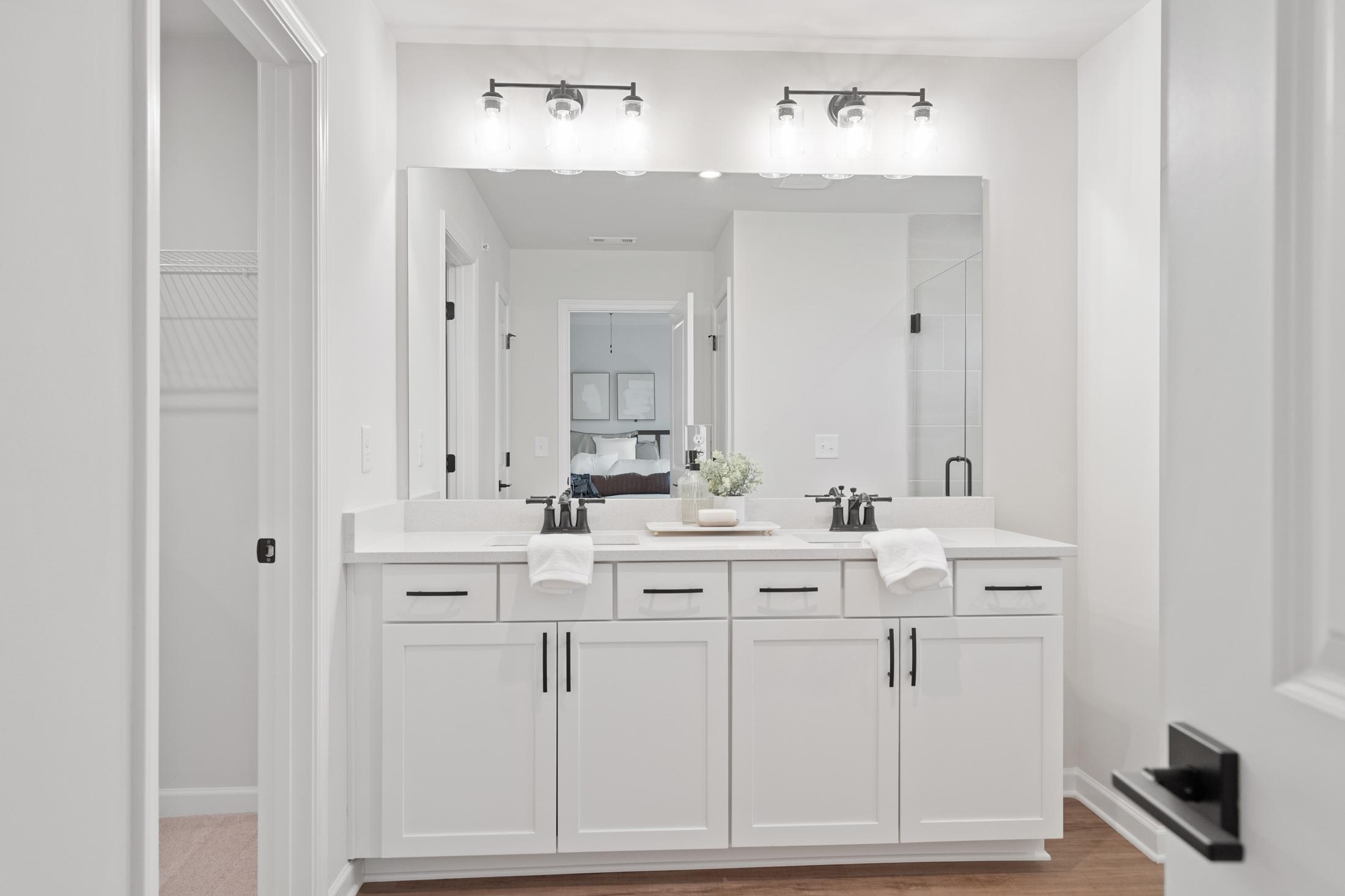 Spacious primary bathroom at Rosehill Townhomes in Marietta GA featuring double white vanity, large mirror, and modern lighting