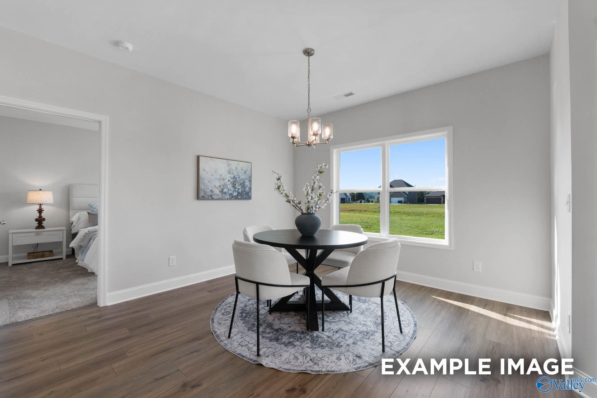 Bright dining area with modern table and chairs in The Franklin C floor plan at Heritage Lakes, New Market, Alabama.