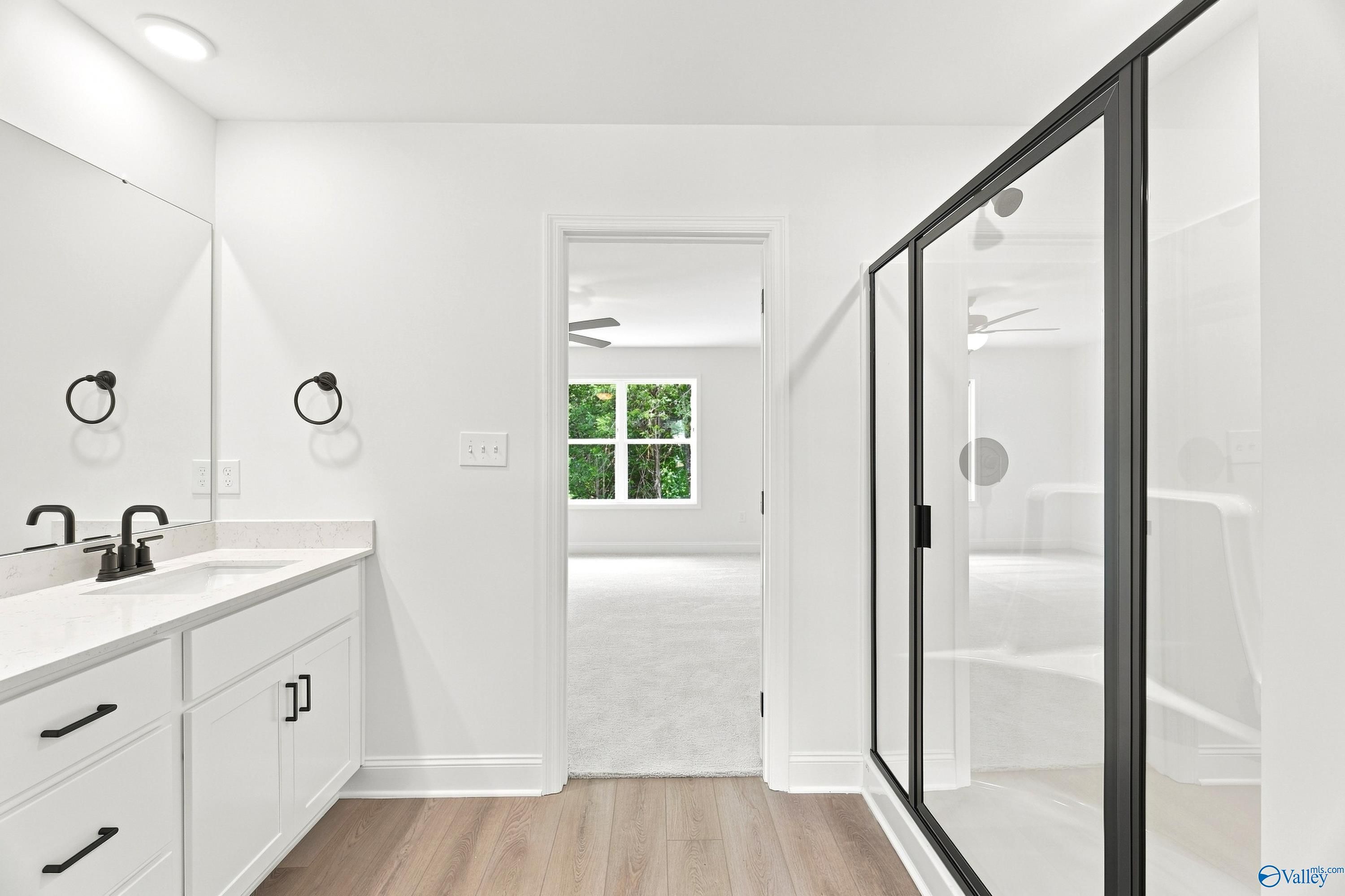 Modern primary bathroom with white vanity and glass shower in The Shelby B floor plan at Jaguar Hills, Huntsville, AL.