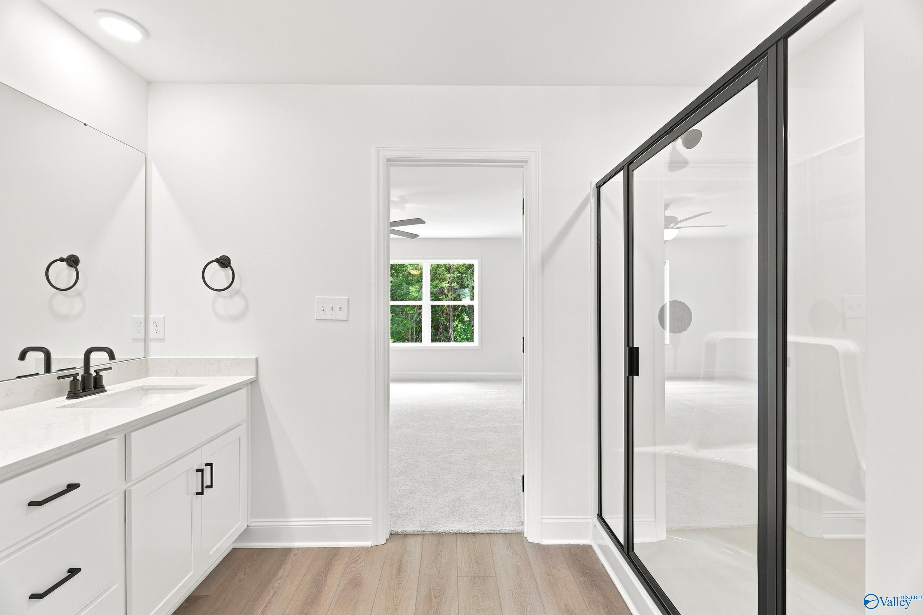 Modern primary bathroom with white vanity and glass shower in The Shelby B floor plan at Jaguar Hills, Huntsville, AL.
