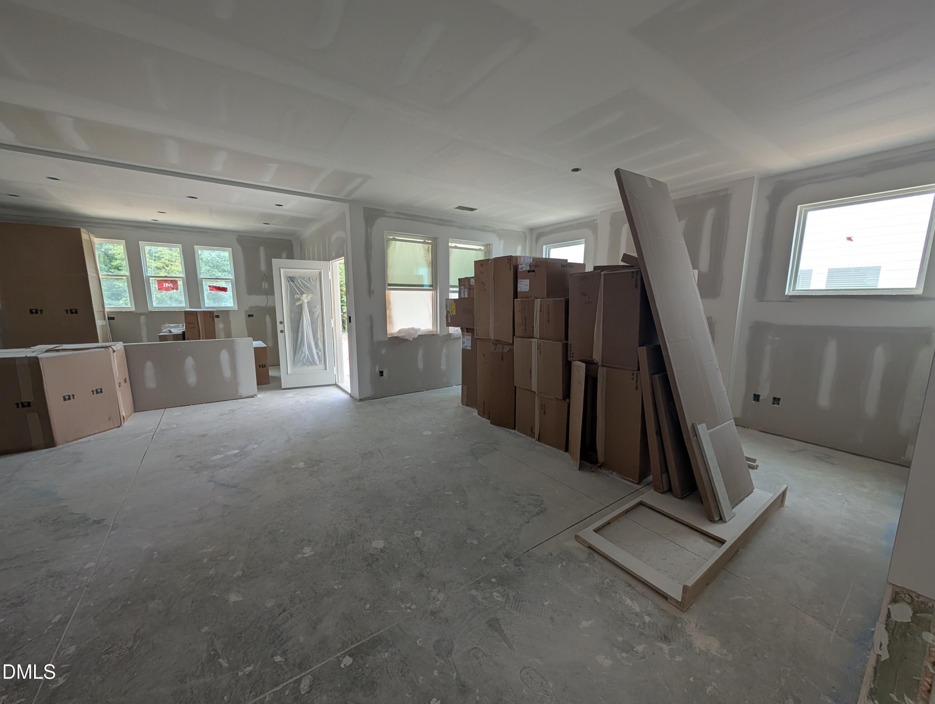 Open-concept interior under construction with stacked cabinetry boxes and drywall in The Aspen C floor plan at Wendell Ridge, Wendell, NC