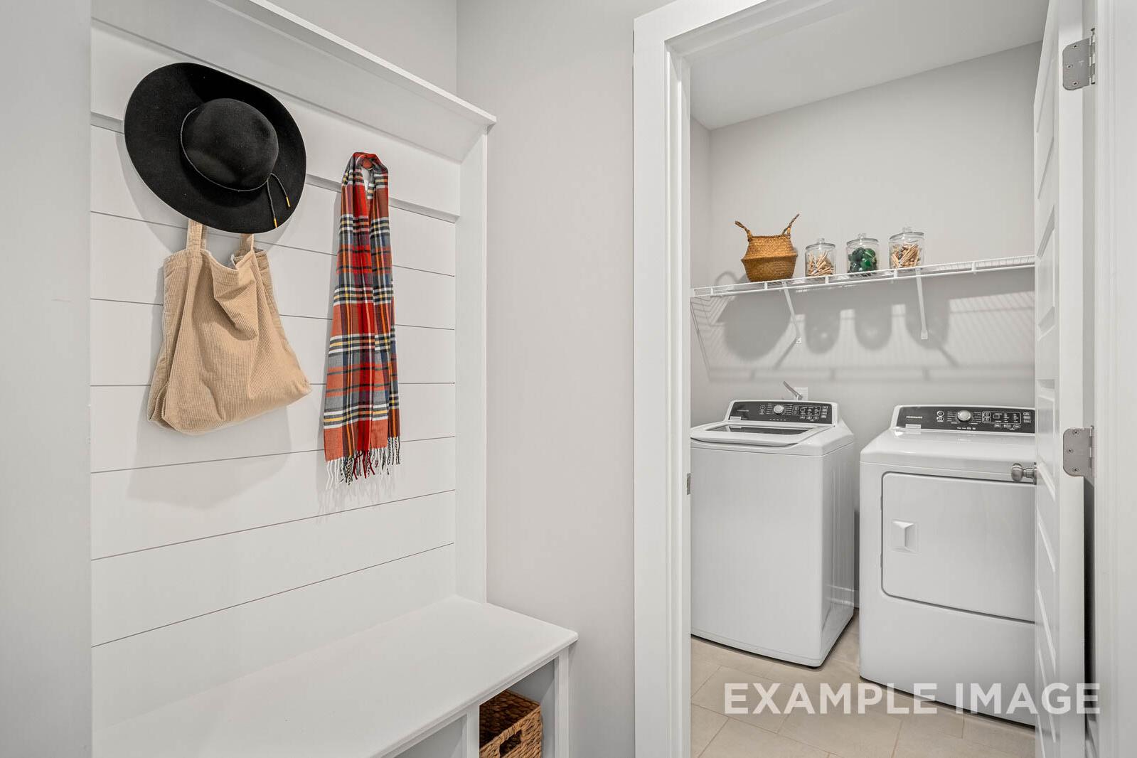 The Franklin B mudroom laundry with washer dryer, built-in bench, coat hooks, plaid scarf, hat, and open shelving
