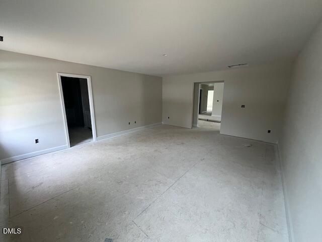 Spacious empty living room with light gray walls, open doorways, and hardwood floors in 4-bedroom The Preston A home, Lillington, NC