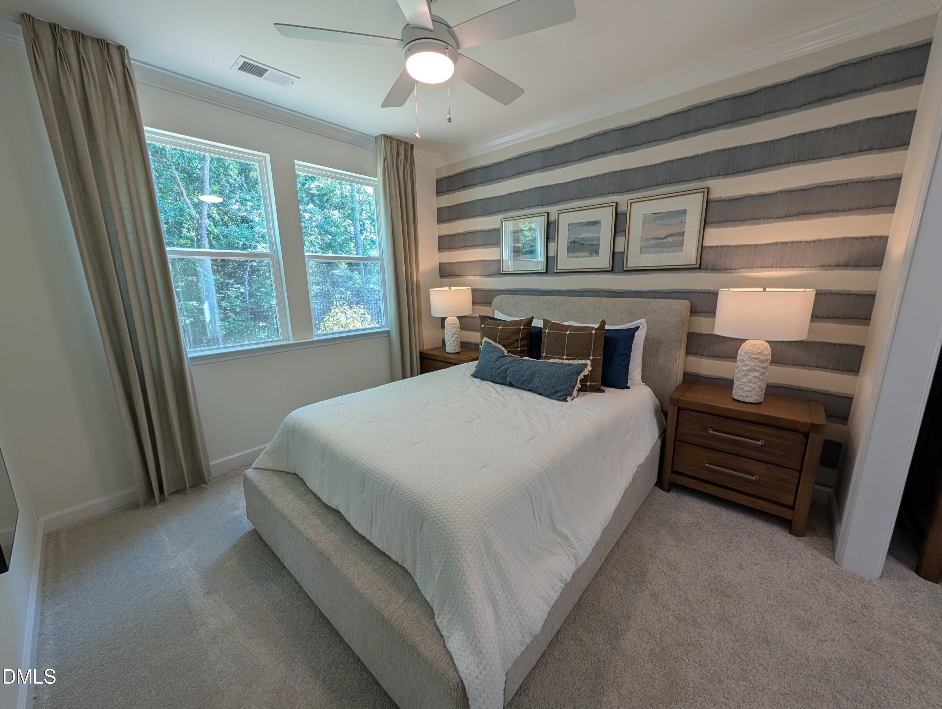 Cozy bedroom with striped accent wall in The Aspen B floor plan at Wendell Ridge in Wendell, North Carolina.