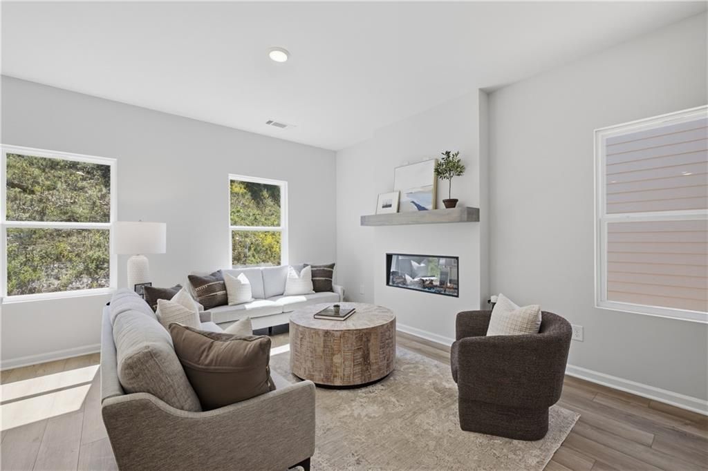 Bright great room with linear fireplace, floating shelf, and natural light in Davidson Homes' Hartwell C, The Bluffs, Canton GA