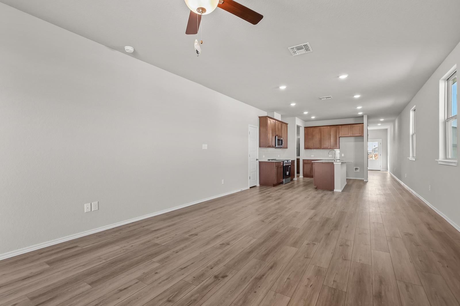 Open-concept living and kitchen area in The Arroyo floor plan featuring wood-look flooring and modern cabinetry.