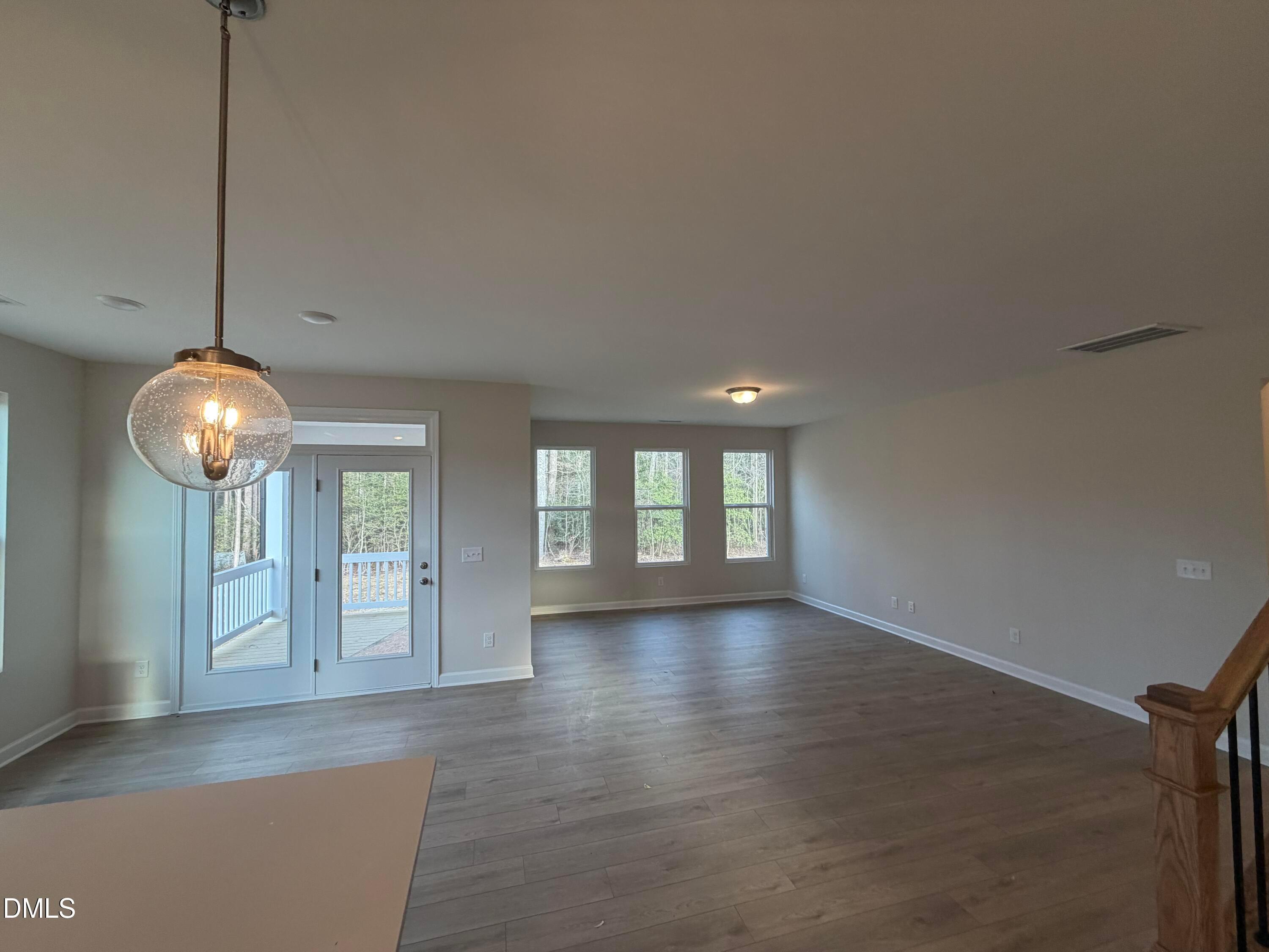 Bright open living room with hardwood floors, large windows, and glass doors to deck in Davidson Homes The Ash B, Lillington, NC