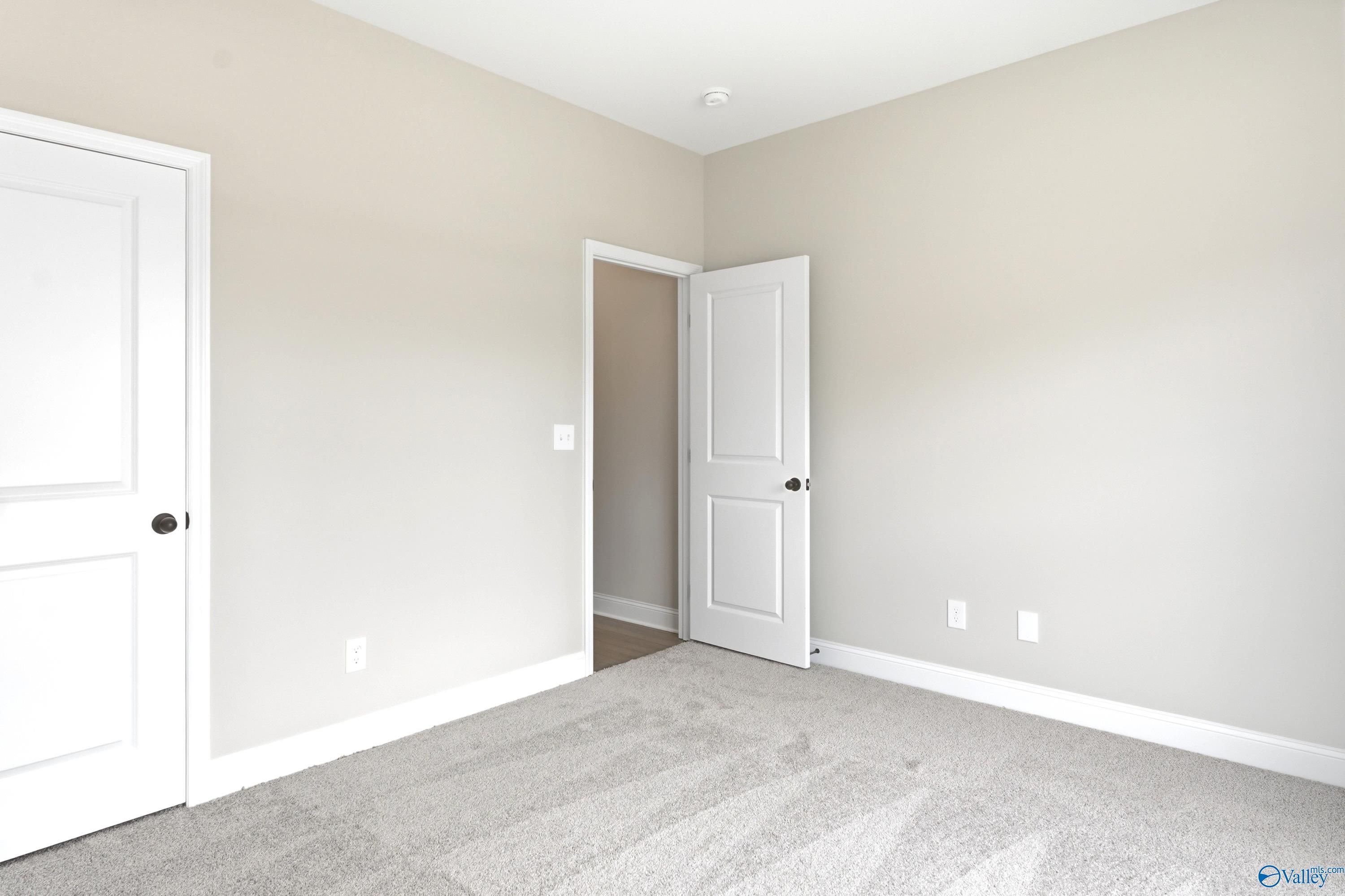 Spacious carpeted bedroom with neutral paint in The Daphne C floor plan by Davidson Homes at Flint Meadows, New Market, AL.