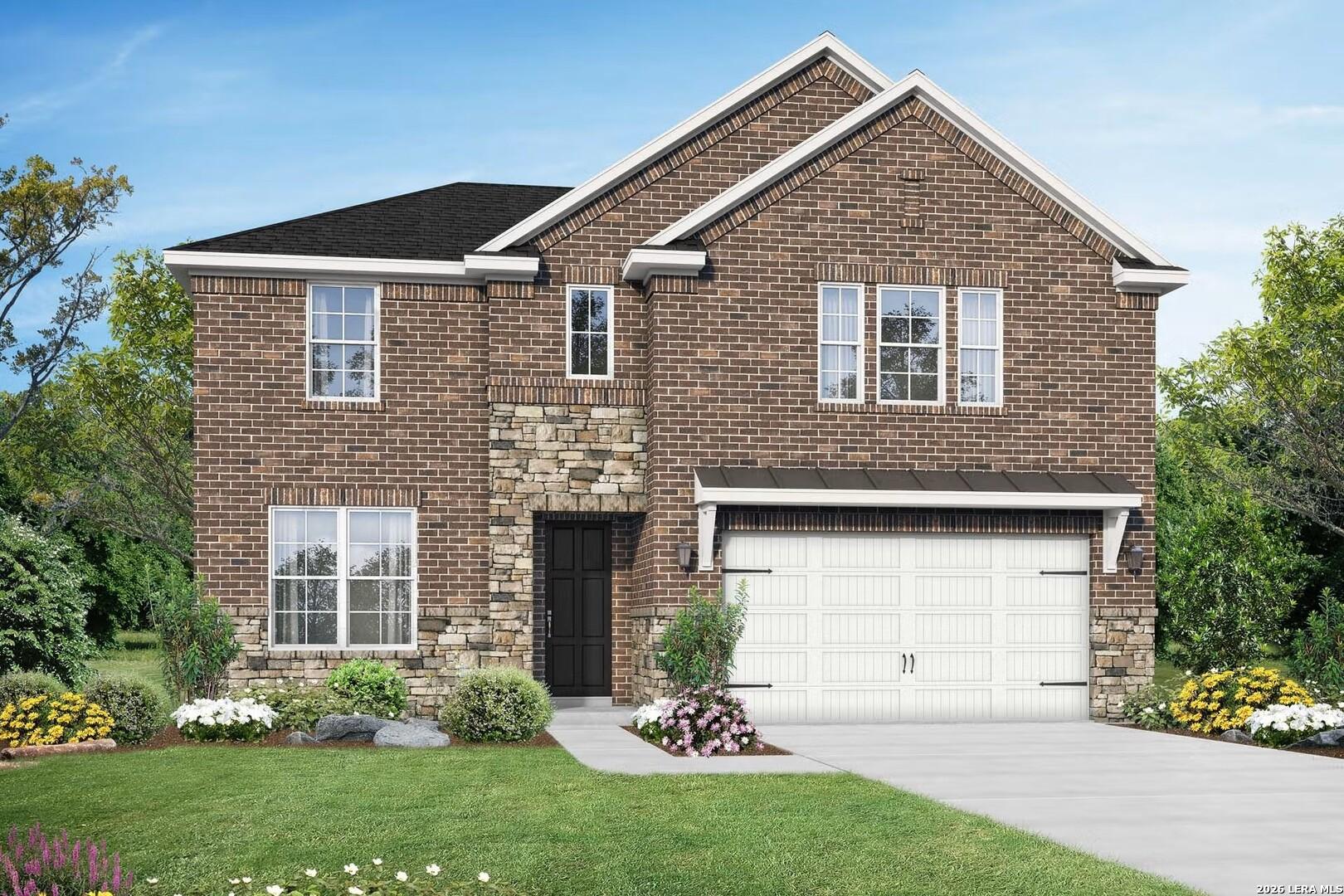 Two-story brick home with stone accents, 2-car garage, vibrant landscaping, and lush lawn in Elmendorf, Texas