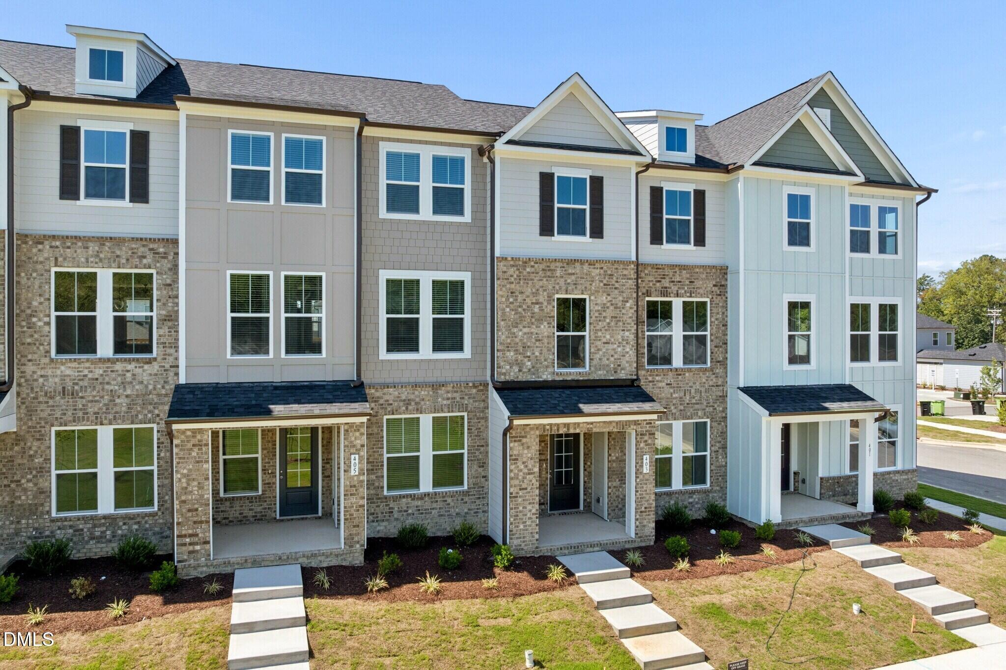 Exterior of 3-story brick townhomes with covered porches at Forestville Yard Townhomes by Davidson Homes in Knightdale, NC