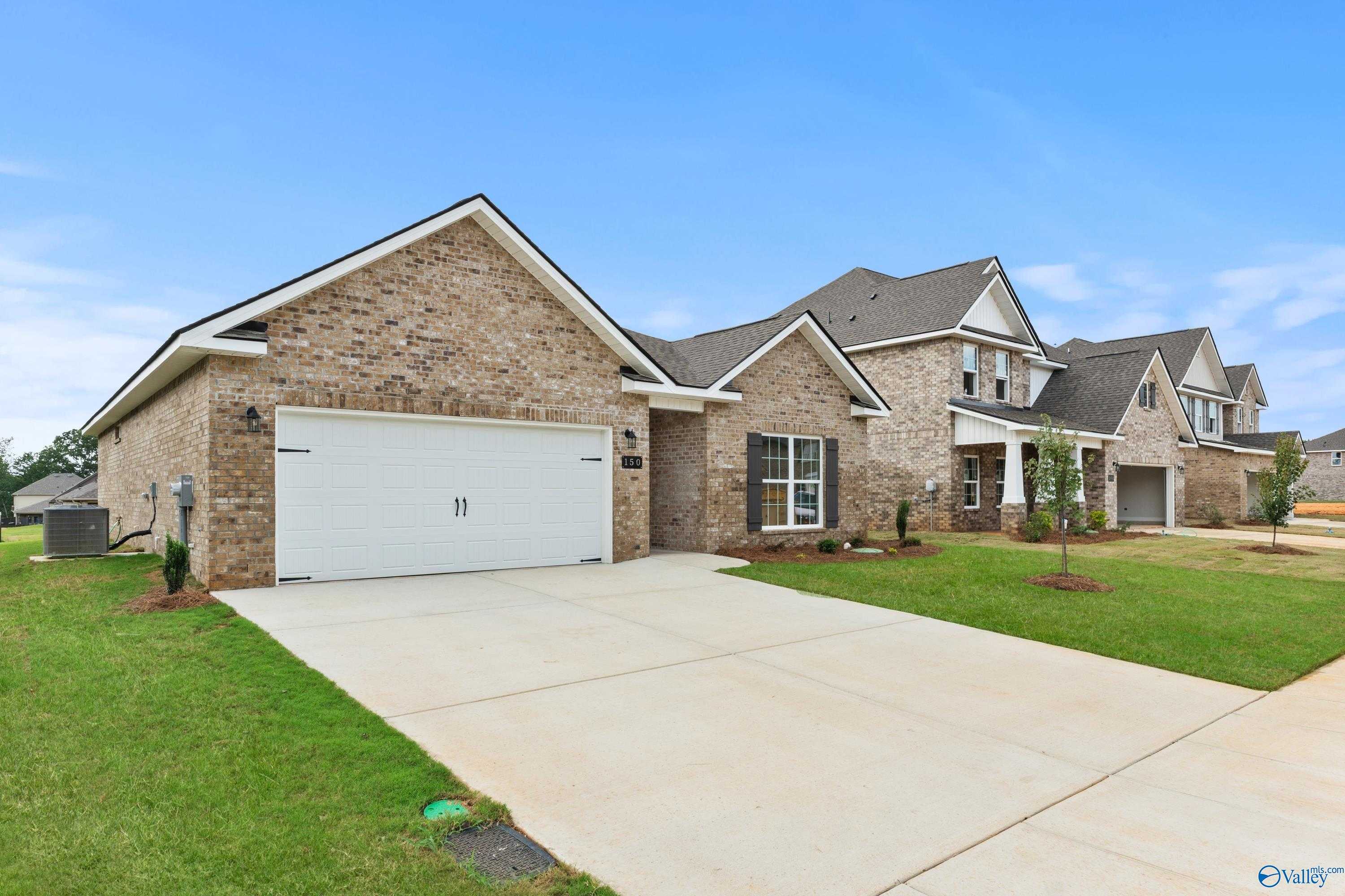 Brick ranch-style home with 2-car garage, white trim, driveway, and green lawn in Creek Grove, New Market, Alabama - Davidson Homes Asheville C