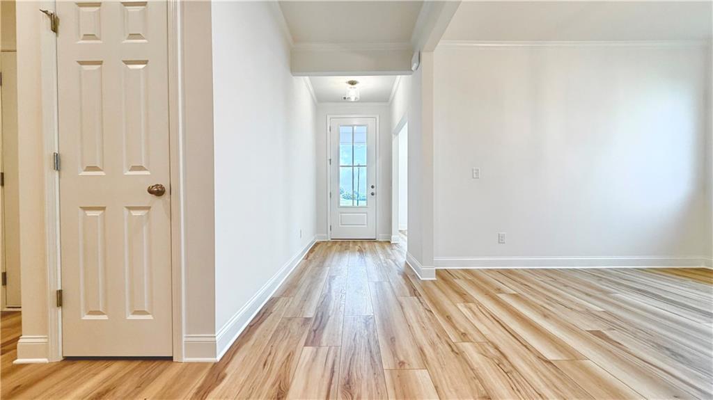 Bright entryway with wood-look flooring in The Glenwood A home by Davidson Homes at Wehunt Meadows in Hoschton, GA.