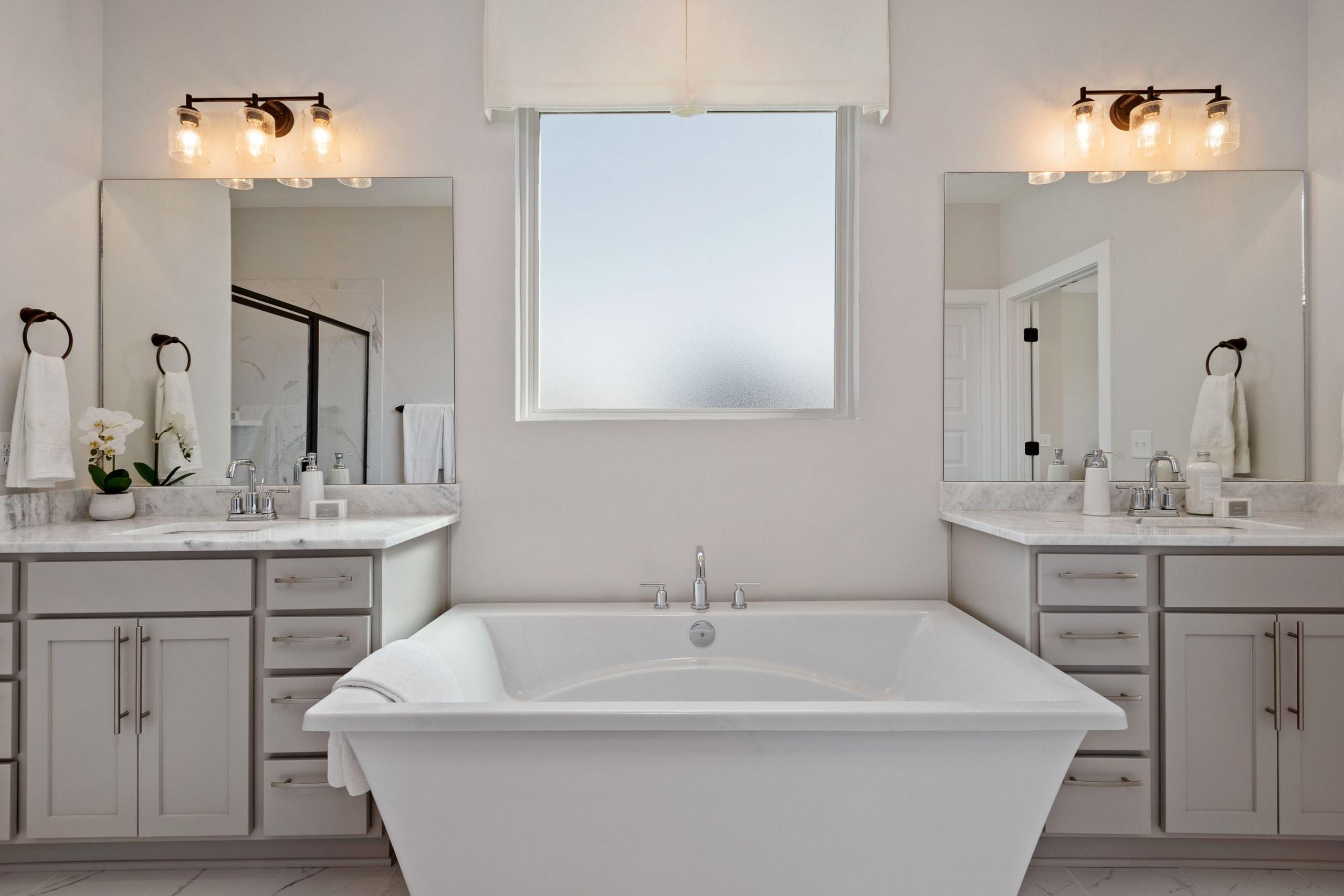 Elegant master bathroom at Rivers Edge in Murfreesboro TN with freestanding tub, double vanity, and frosted window