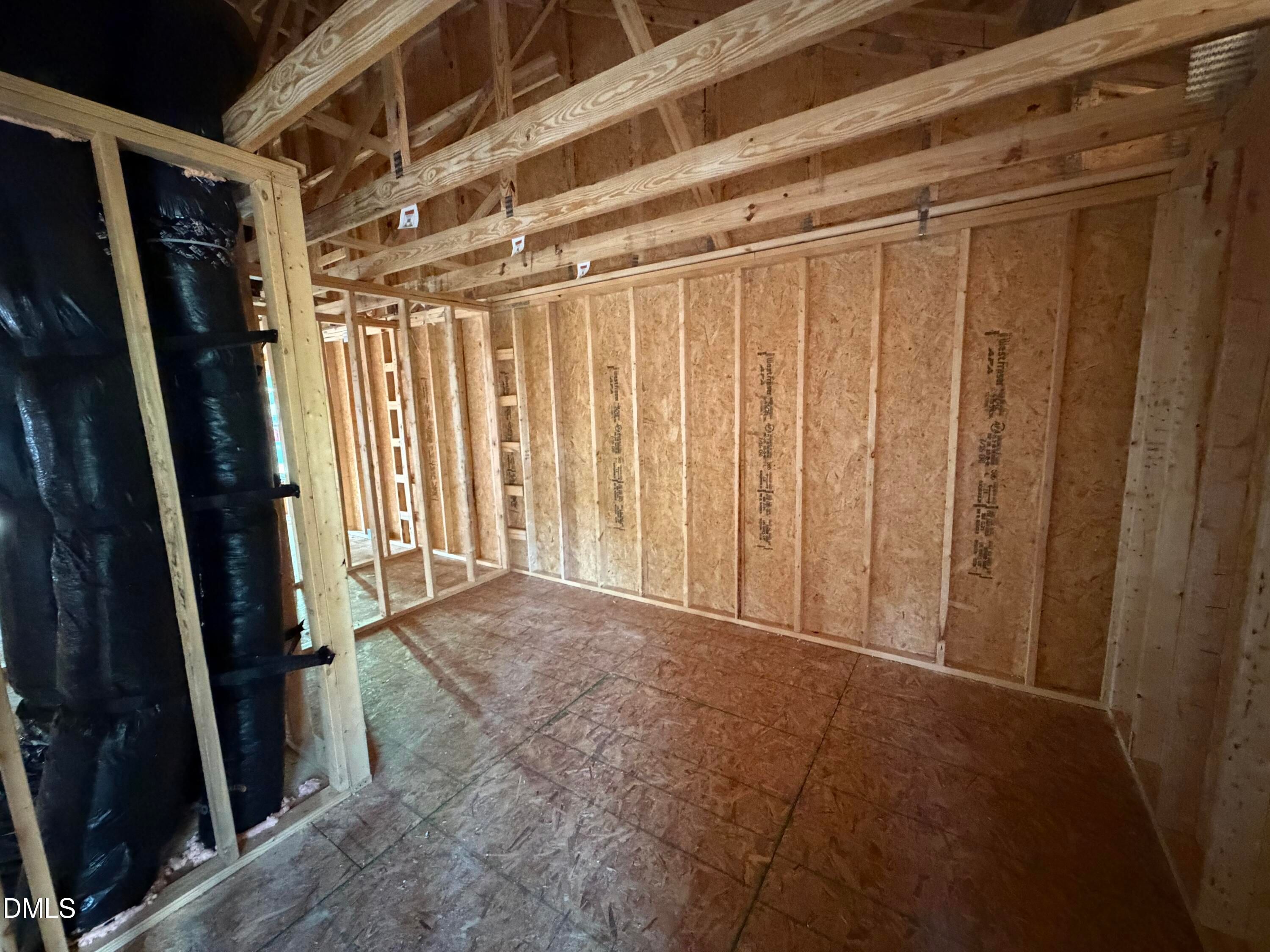 Unfinished upstairs room with exposed wood framing and OSB walls in Davidson Homes' The Beech floor plan at Wendell Ridge, NC