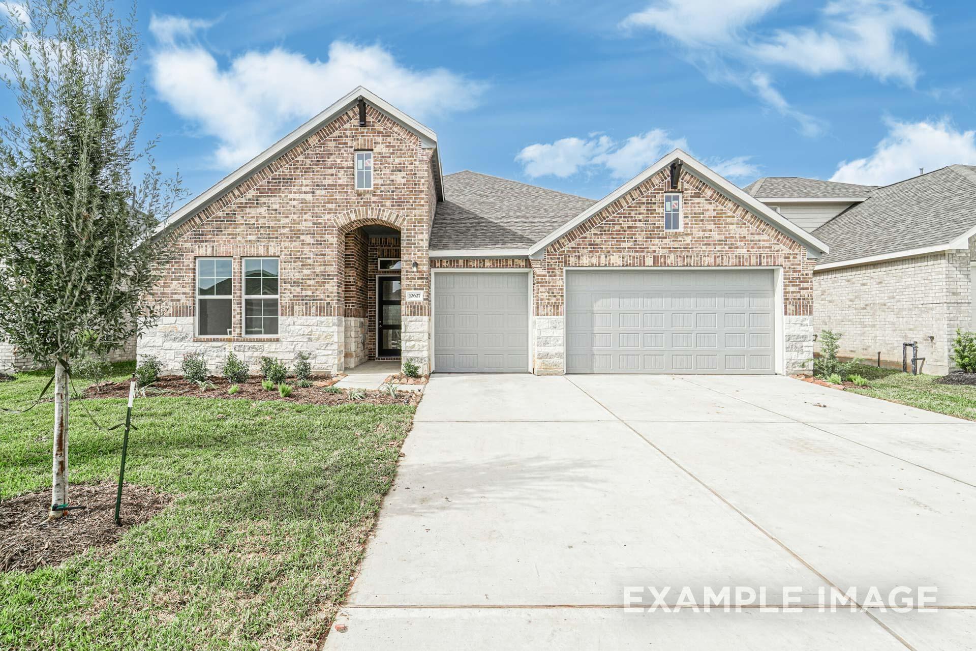 Modern brick and stone facade of The George B 4-bedroom single-story home with 3-car garage and driveway in Rosharon, Texas