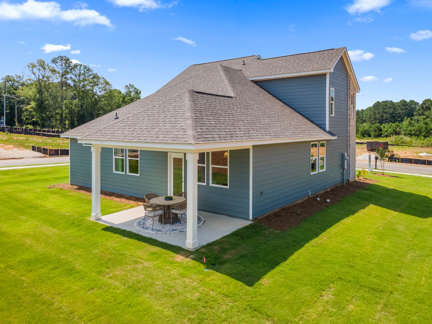 Back patio of a Davidson Homes house in Links Crossing, Auburn, Alabama, featuring a covered porch and outdoor seating.