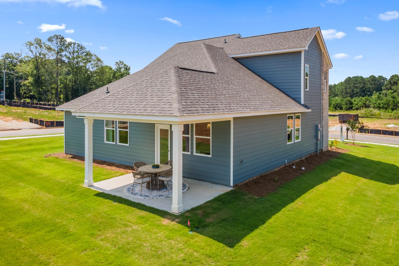 Back patio of a Davidson Homes house in Links Crossing, Auburn, Alabama, featuring a covered porch and outdoor seating.
