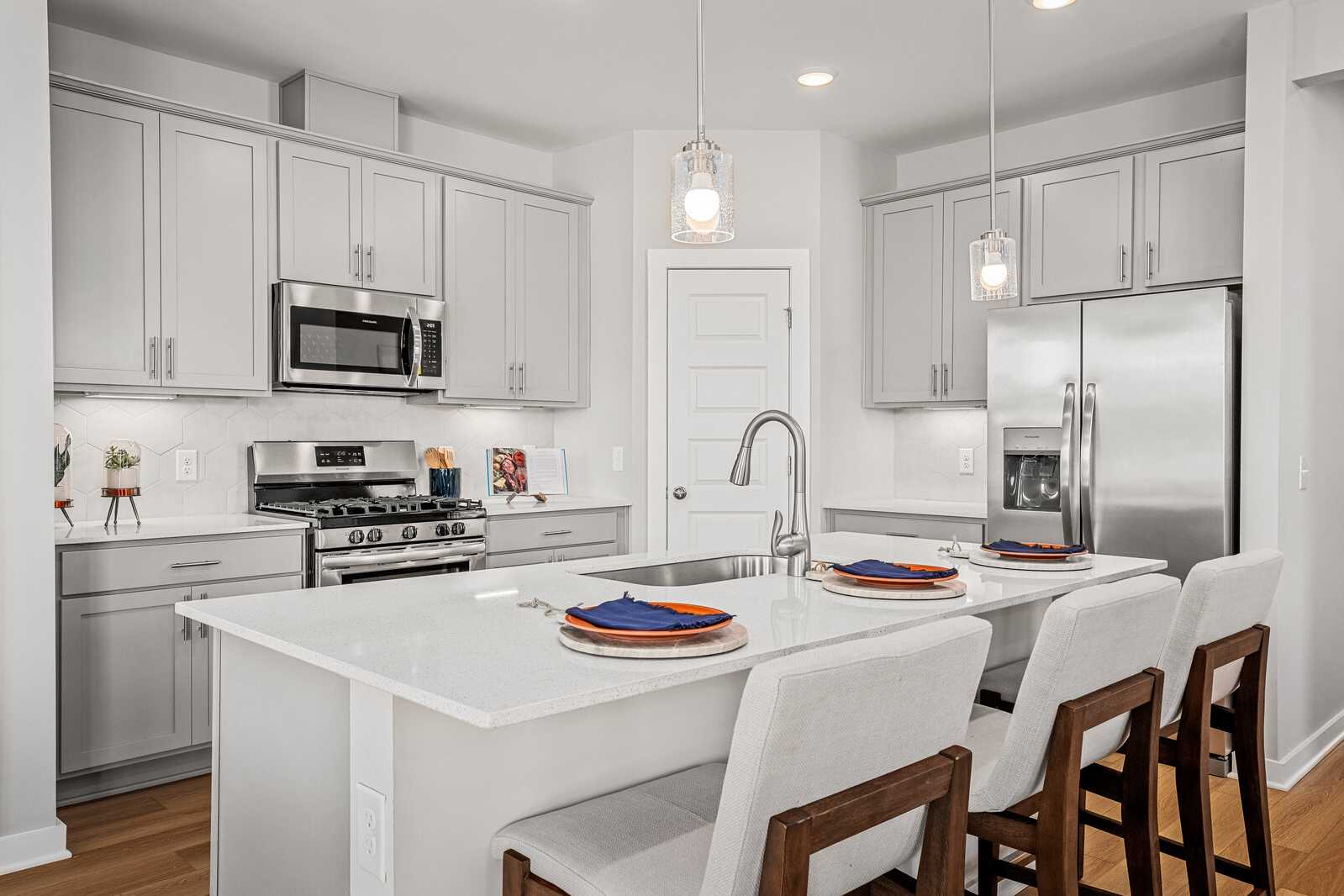 Spacious modern kitchen at Sage Farms in White House TN with white shaker cabinets, stainless steel appliances, and quartz island
