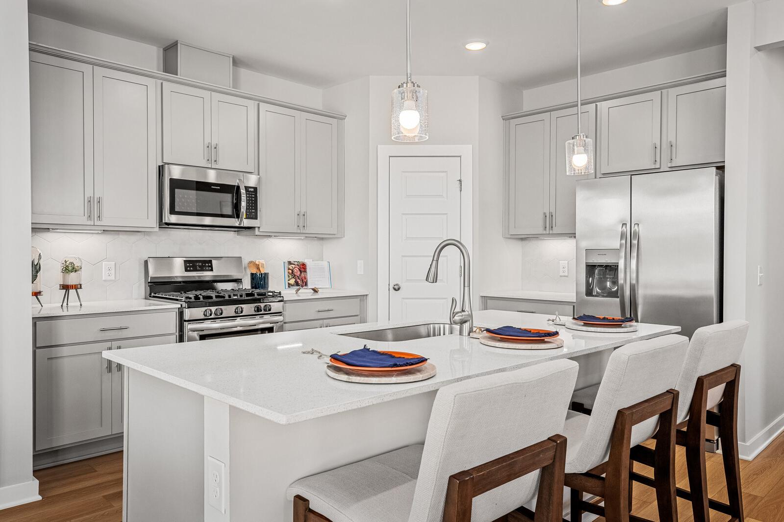 Spacious modern kitchen at Sage Farms in White House TN with white shaker cabinets, stainless steel appliances, and quartz island