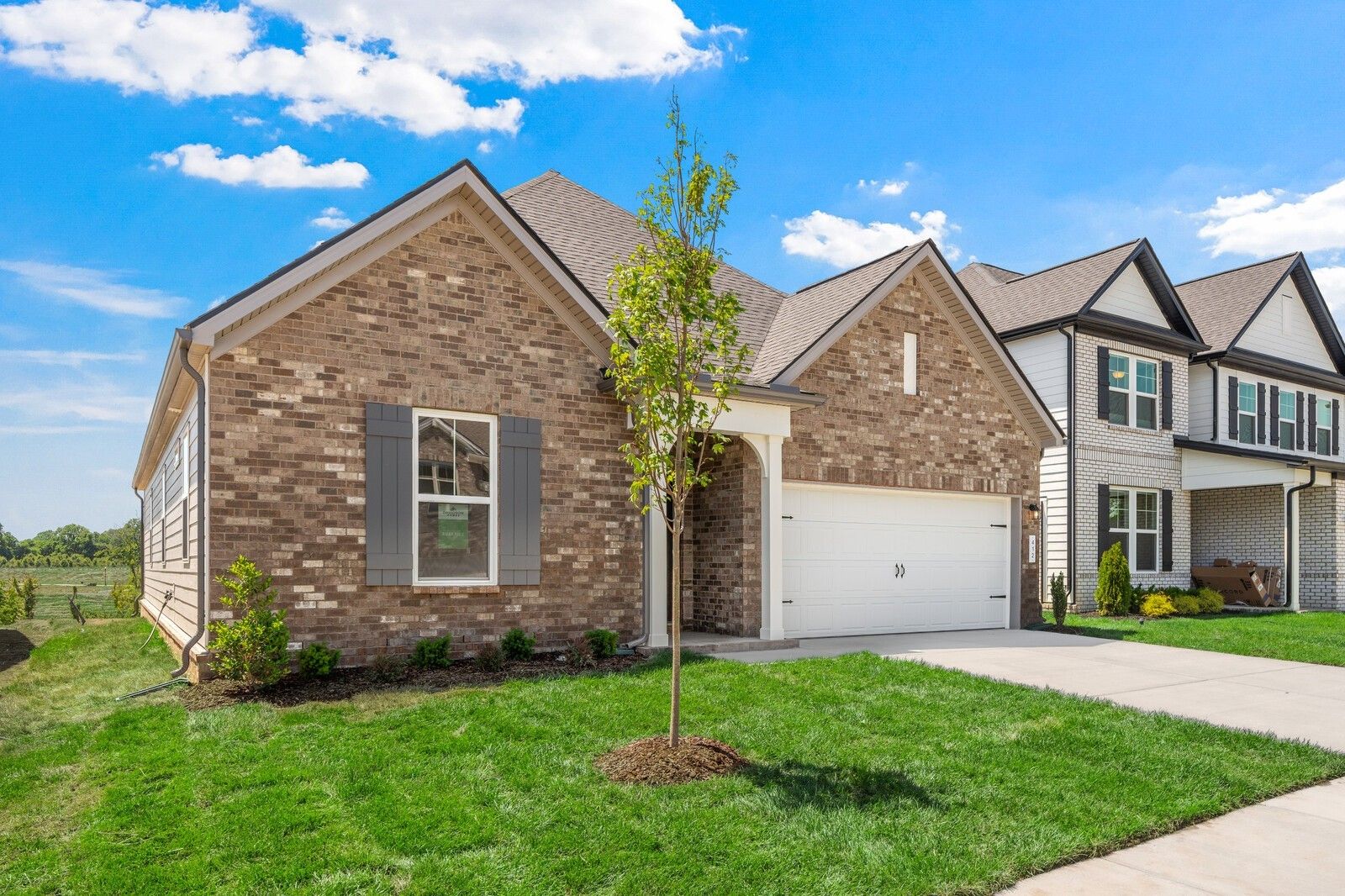 Brick-exterior, 1-story The Cottonwood E floor plan by Davidson Homes in Woods Crossing, Gallatin, Tennessee with 2-car garage.