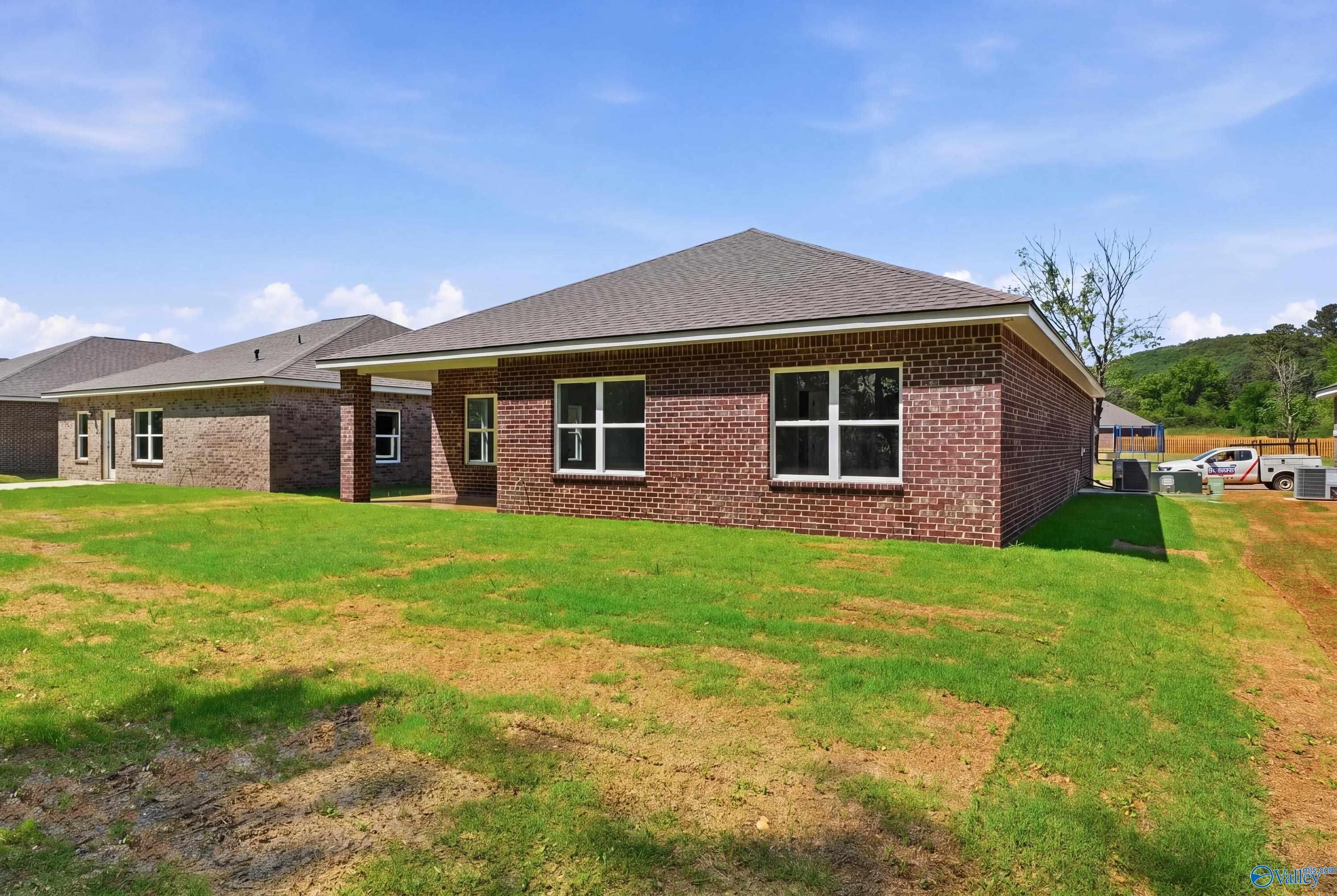 Brick single-story 3-bedroom home with gabled roof, large windows, and green lawn in Jaguar Hills, Huntsville, Alabama by Davidson Homes The Franklin