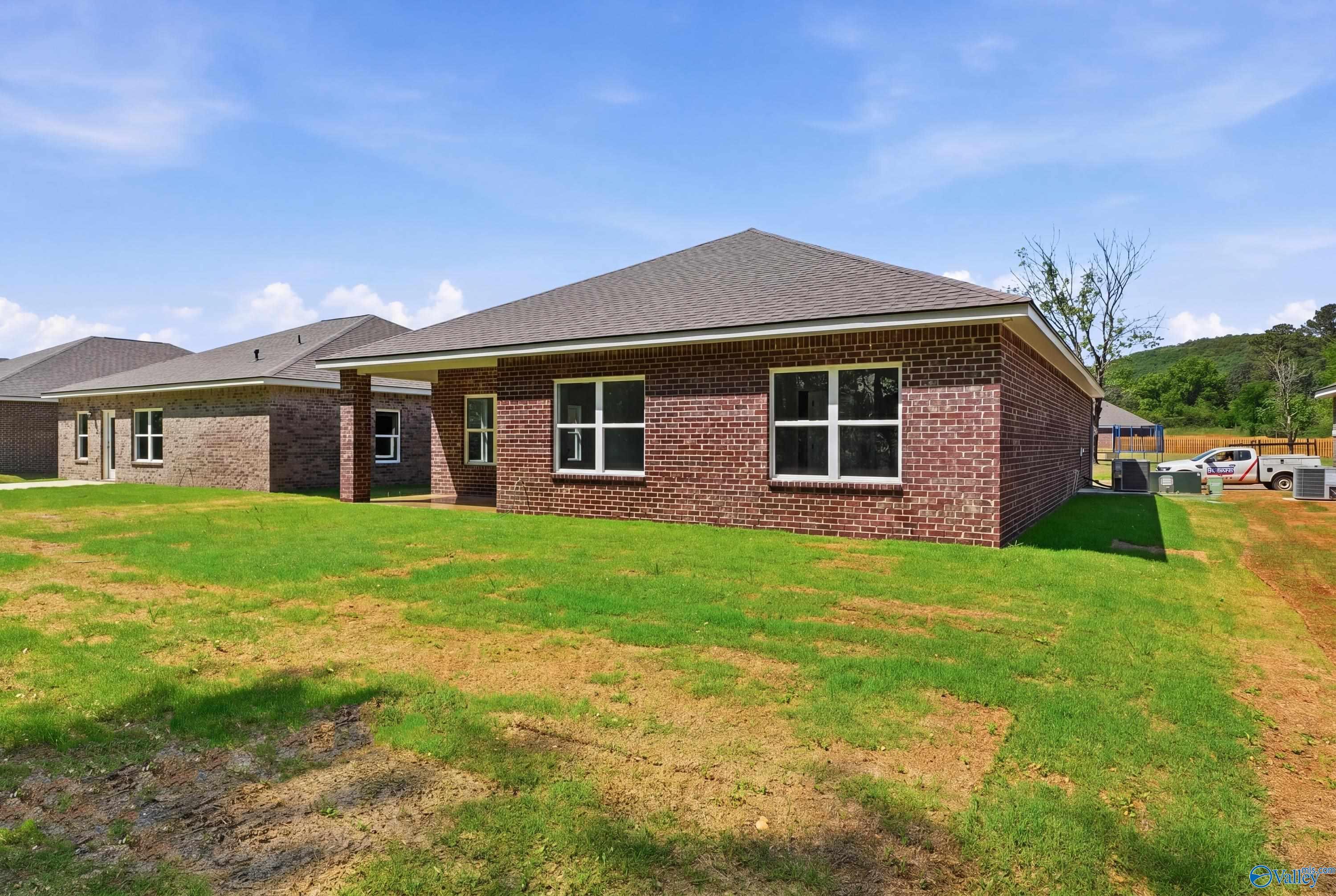 Brick single-story 3-bedroom home with gabled roof, large windows, and green lawn in Jaguar Hills, Huntsville, Alabama by Davidson Homes The Franklin