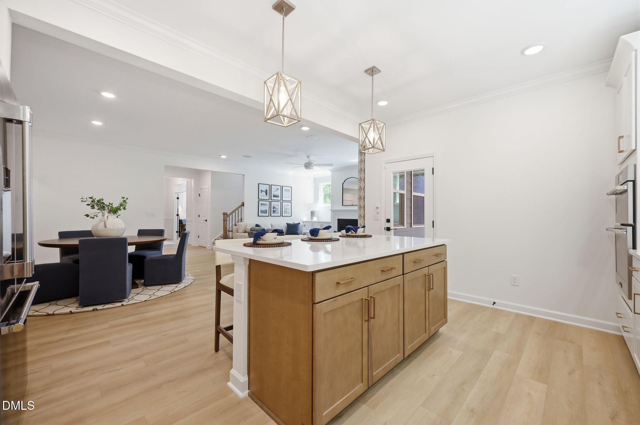 Modern kitchen island with pendant lighting overlooking dining room in The Aspen B floor plan at Wendell Ridge, NC.