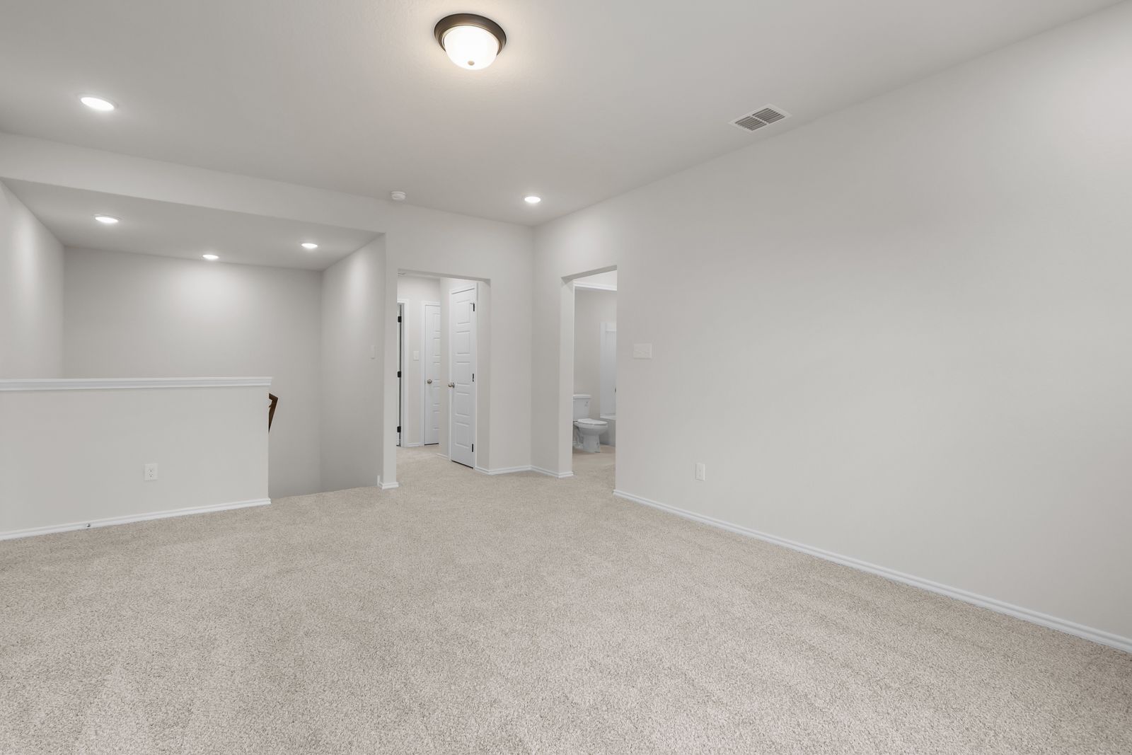Spacious upstairs loft area in The Sequoia C floor plan featuring neutral carpeting and recessed lighting.