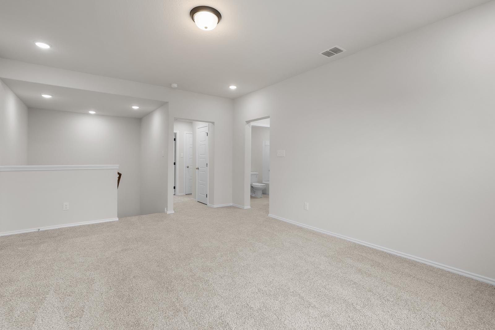 Spacious upstairs loft area in The Sequoia C floor plan featuring neutral carpeting and recessed lighting.