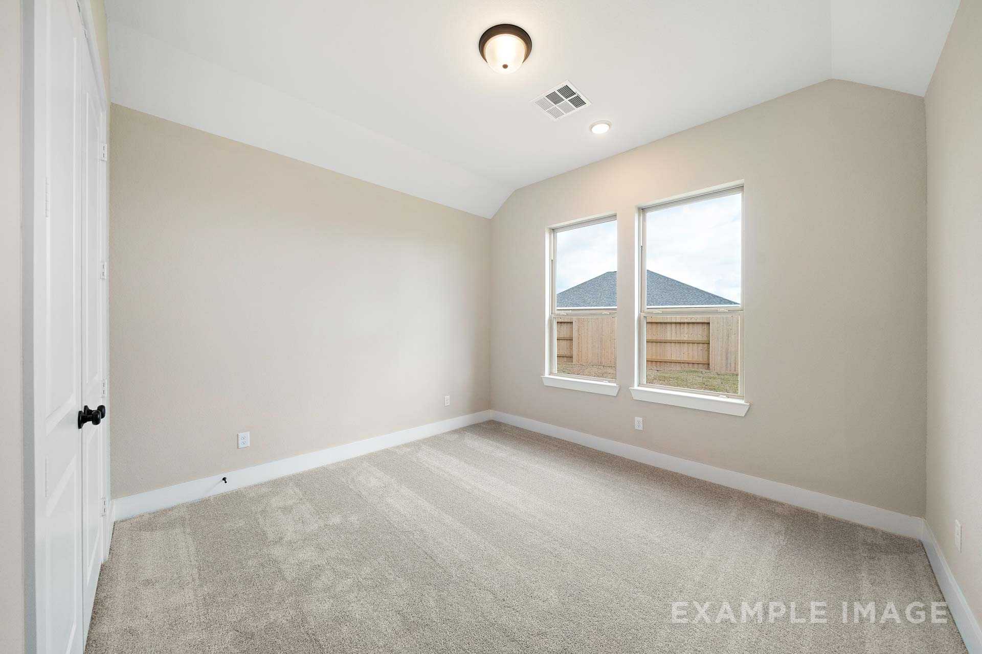 Spacious secondary bedroom in The Elizabeth A with beige walls, gray carpet, large windows, and ceiling fan