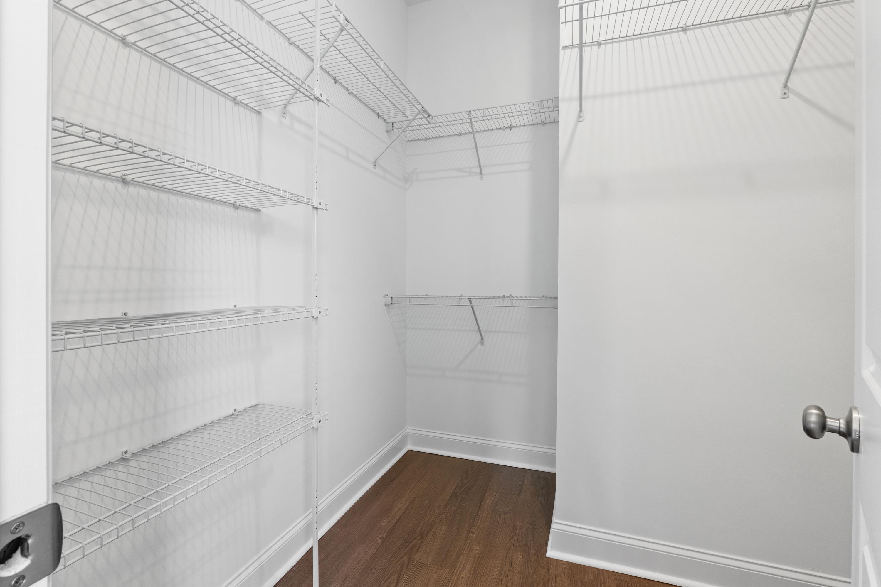 Spacious walk-in closet in The Haven D master suite featuring white wire shelving, hanging rods, and hardwood flooring