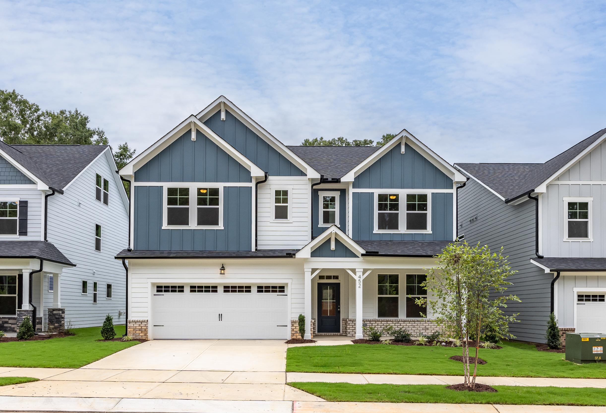 Navy blue two-story The Beech B elevation with gabled roof, two-car garage, front porch, and landscaped yard in Belmont NC
